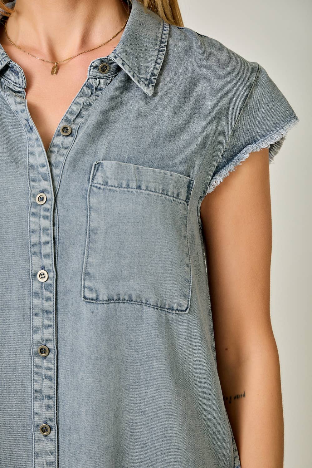Close up of pocket of Fringe Hem Tencel Shirt Dress in Washed Black — button-down front, flutter cap sleeves, fringed hi-lo hem, and side pockets

