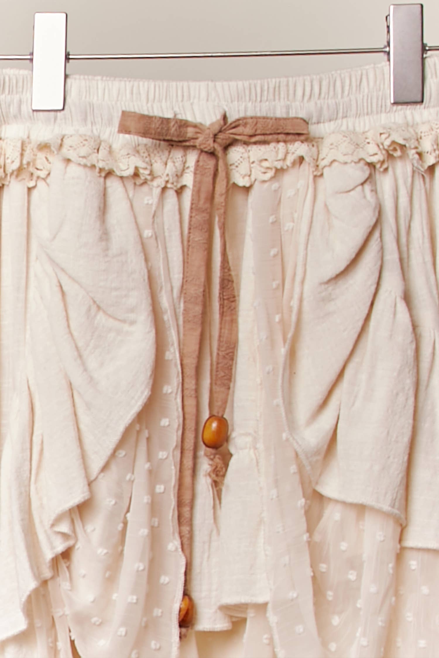 Ivory maxi skirt detail - close-up of intricate layered ruffles, wooden beads and meticulous tiered construction