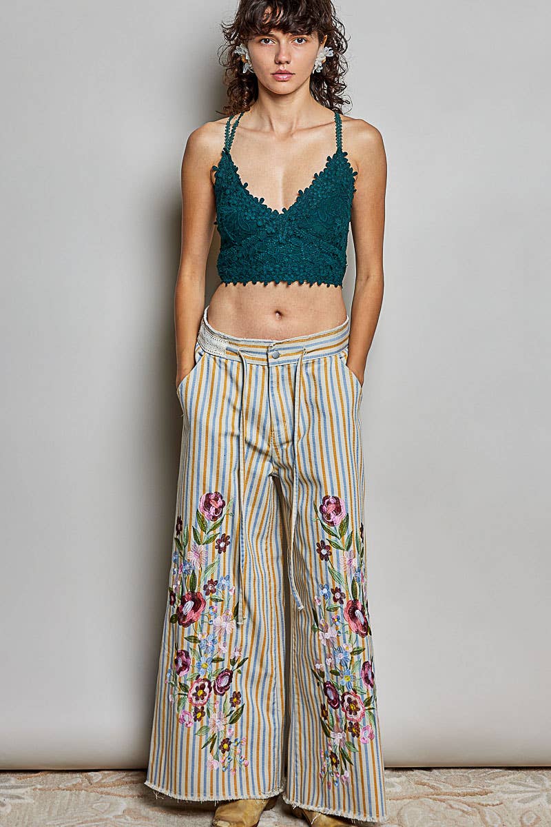 Marigold Revival striped wide-leg jeans with colorful floral embroidery, styled with a teal lace crop top.
