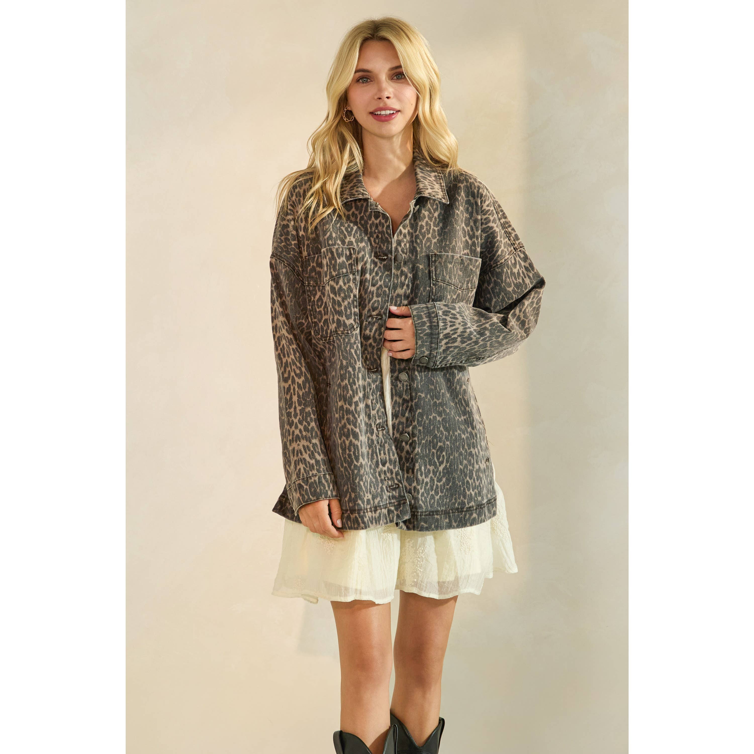 Oversized camouflage print jacket with front pockets and button closure, styled over a white tiered mini dress.
