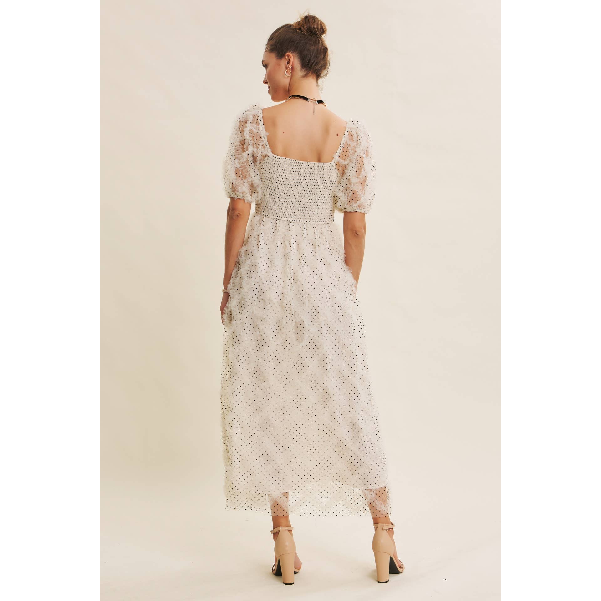 Back view — cream polka-dot tulle midi dress with puff sleeves, square back neckline and smocked bodice, on model.