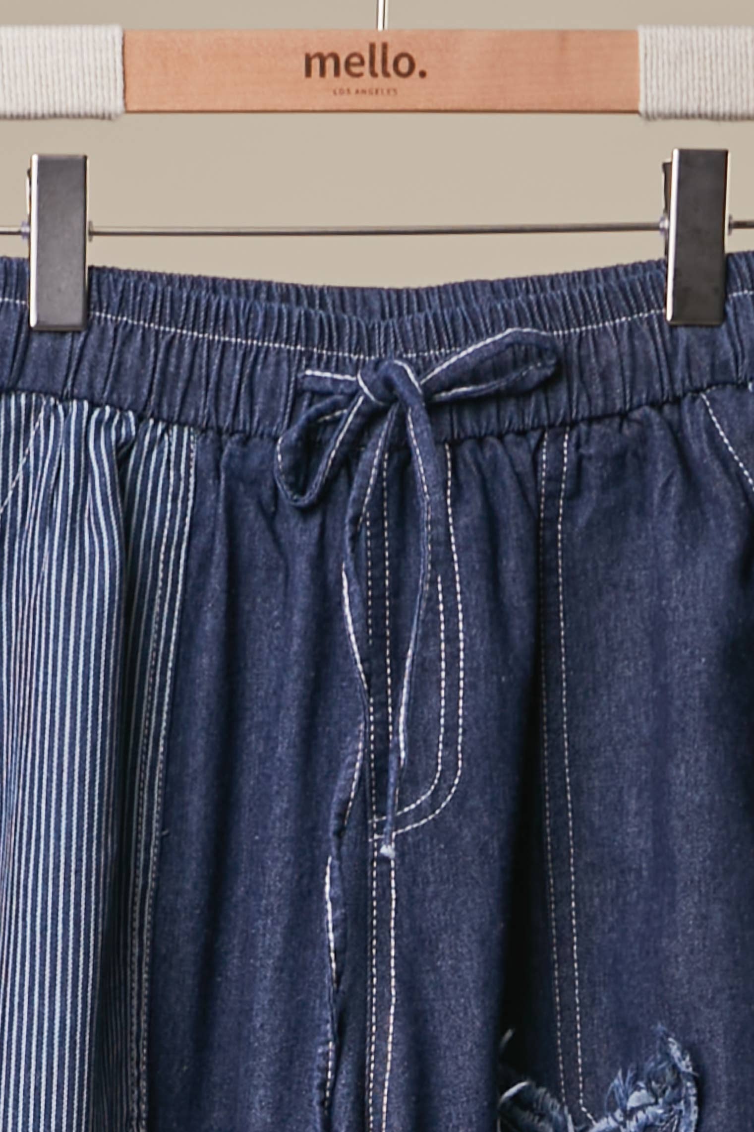 Close up of Blue Star Wide Leg Patchwork Denim Pants in dark blue wash with frayed star patches, elastic waist and drawstring — boho wide leg style by Mello