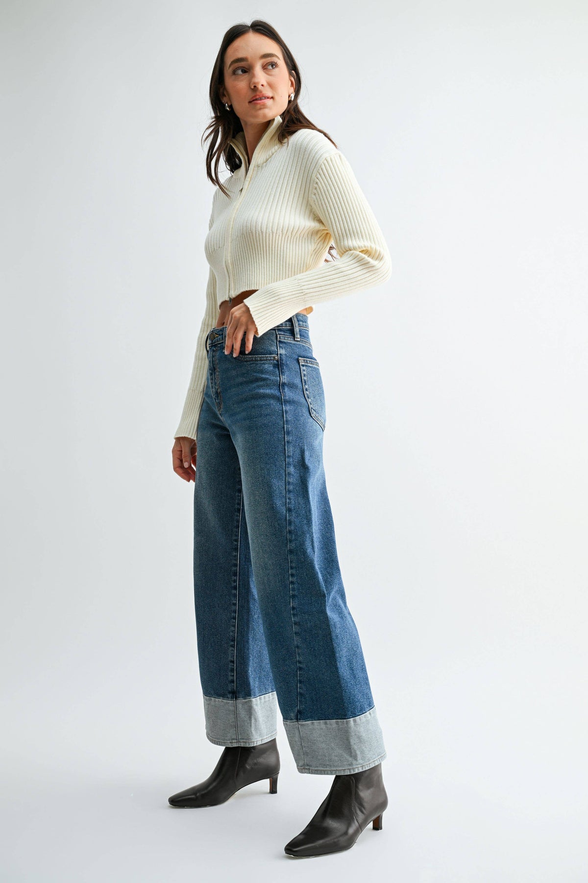 Side-angle view of Blue Hour Two-Tone Wide Leg Jeans showing the wide-leg silhouette and contrasting light denim hems.
