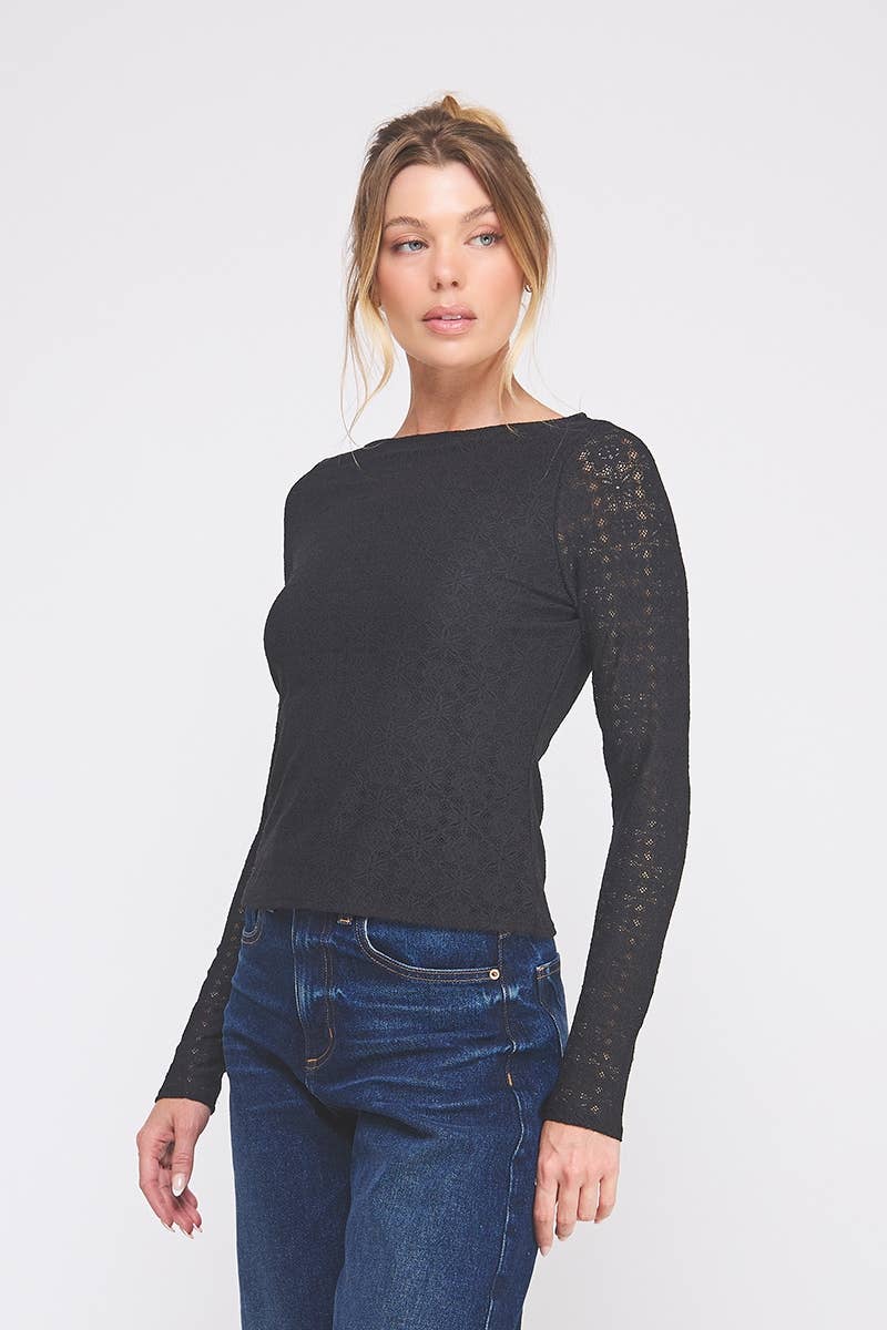 Woman wearing a black long-sleeve top with lace details on a white background