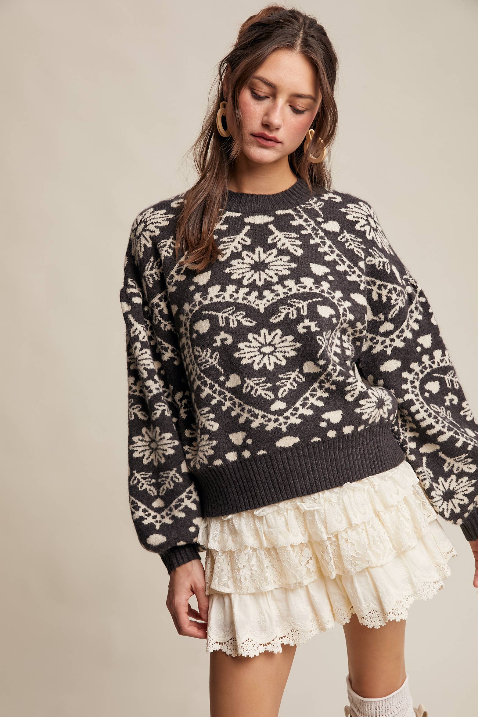 Charcoal crewneck sweater with cream floral heart–motif jacquard, puff sleeves, and ribbed cuffs and hem.