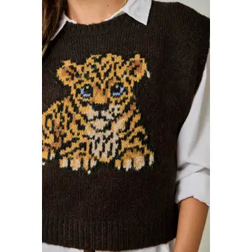 Close-up of the leopard cub graphic on a dark brown knit sweater vest, showing the ribbed neckline and hem.

