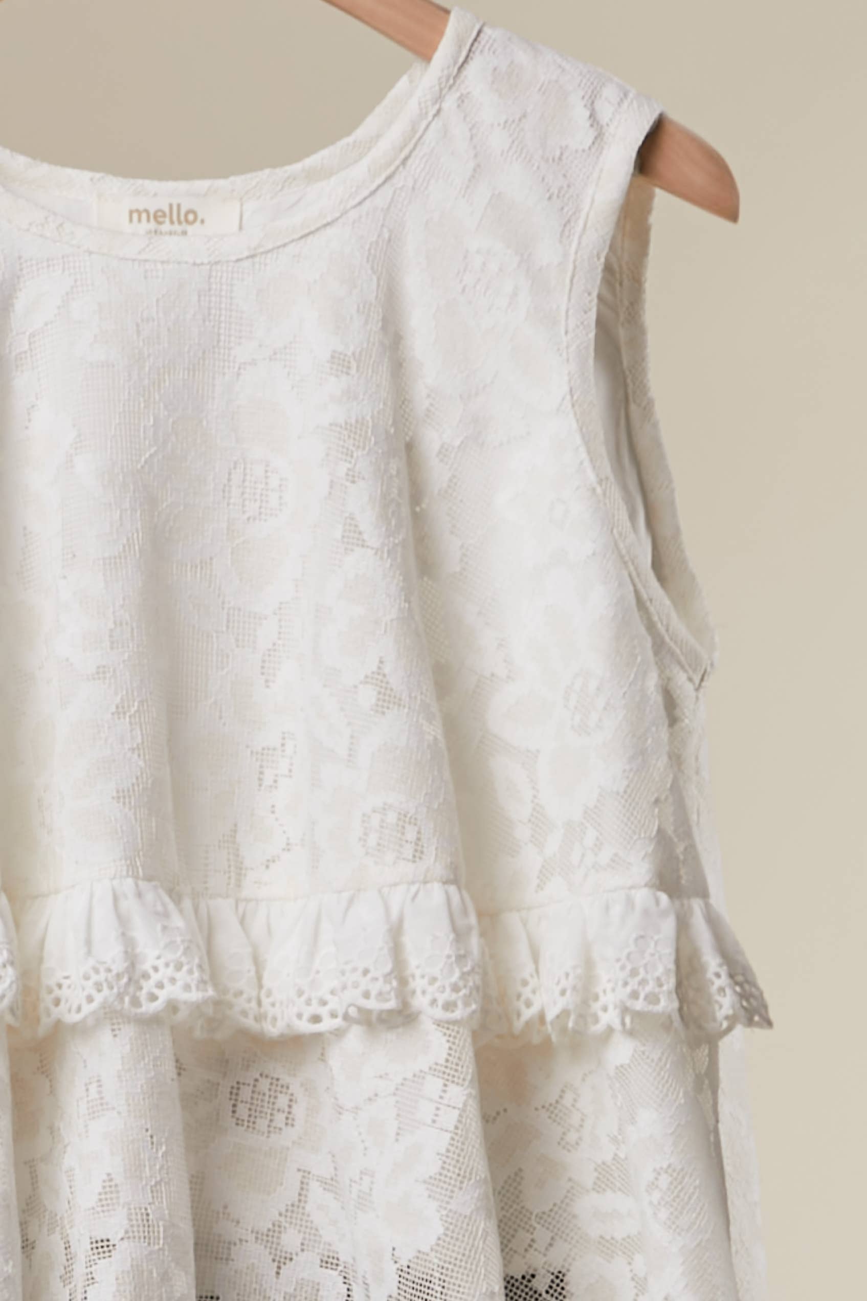White lace dress on a hanger Grace Lace - elegant high-low hemline with dimensional layered lace construction