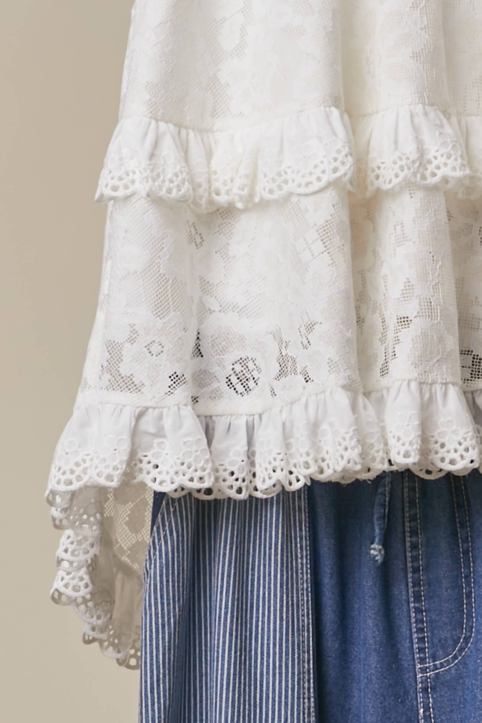 Layered lace tunic detail - close-up of intricate lace detailing and elegant high-low silhouette