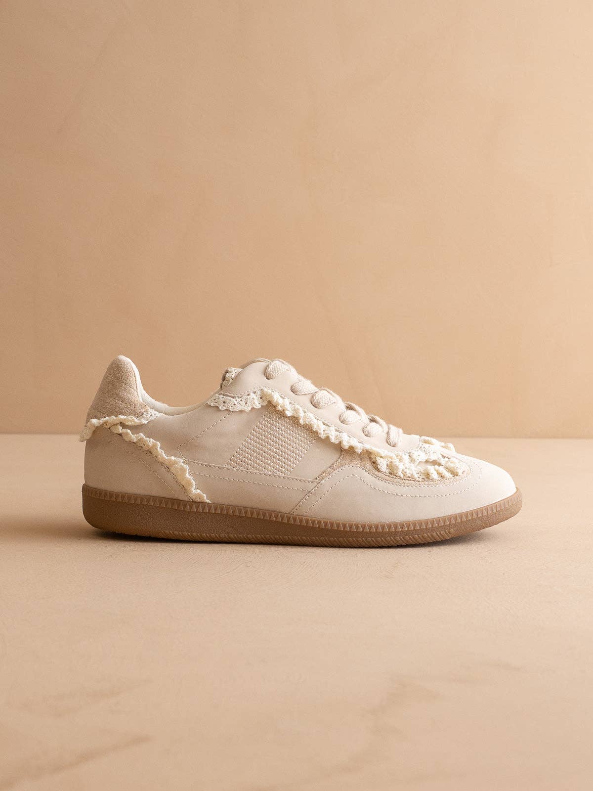 Women’s ivory low-top sneaker with crochet lace trim and gum rubber sole, side view.