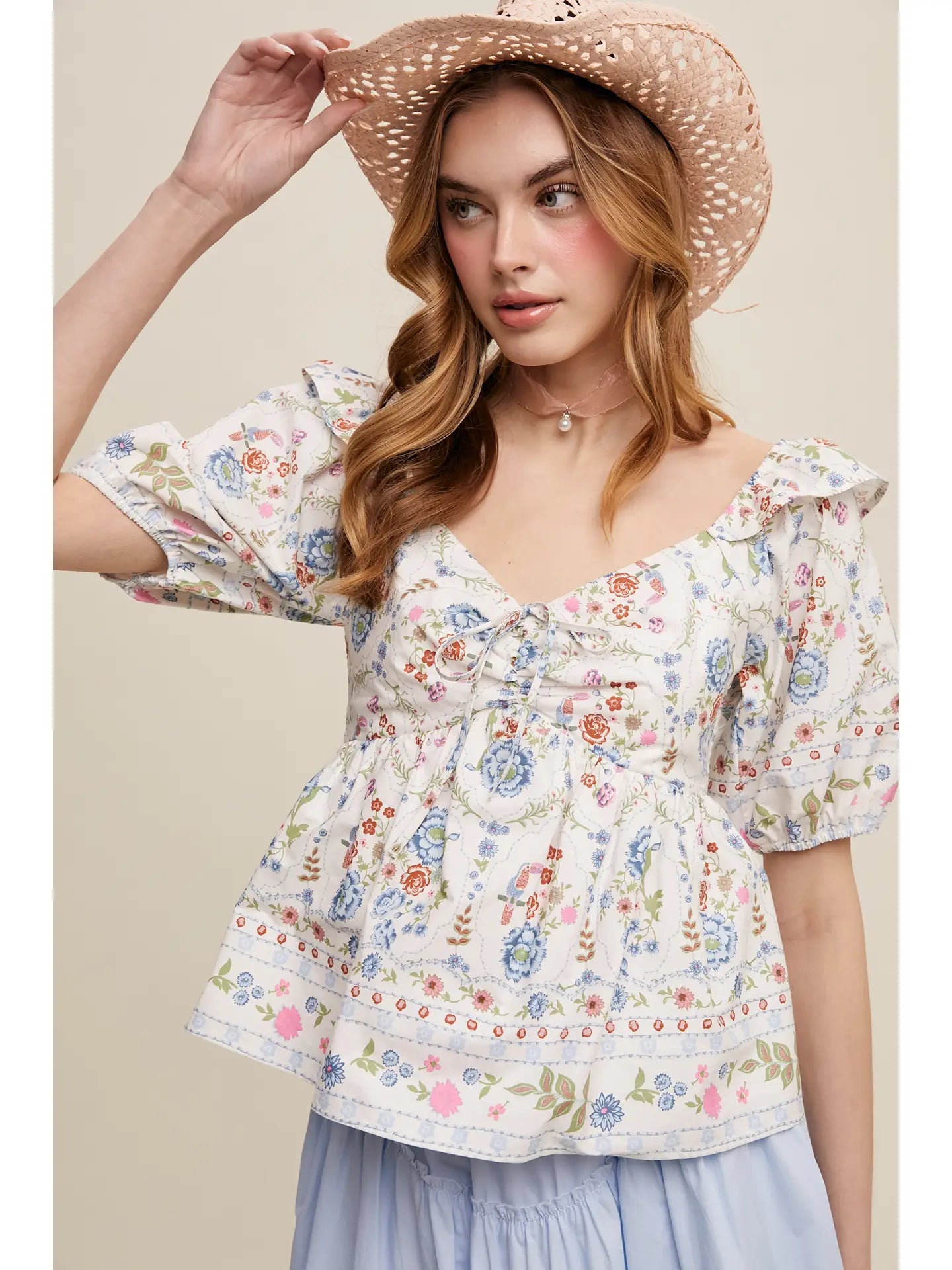 Woman wearing a floral patterned crop top with puff sleeves