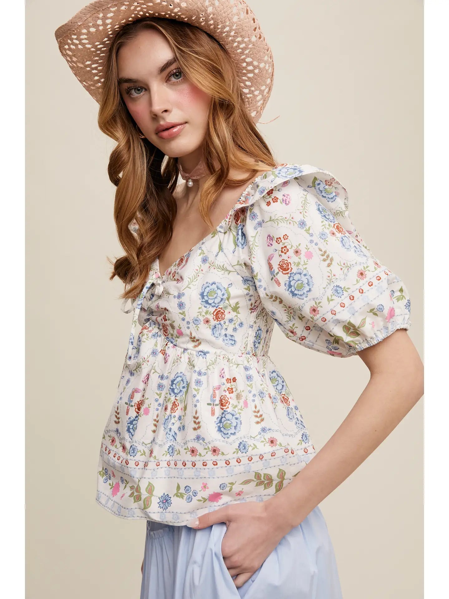 Woman wearing a floral patterned crop top with puff sleeves