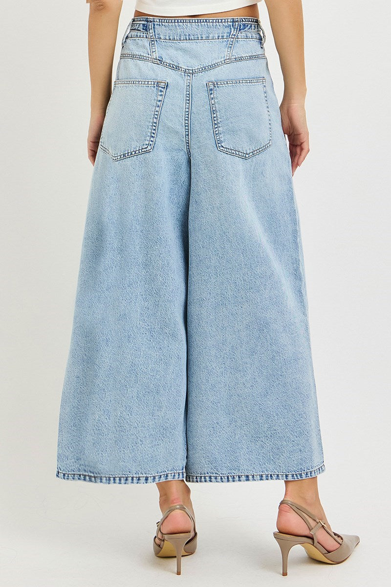 Light blue denim wide-leg jeans worn by a person on a white background