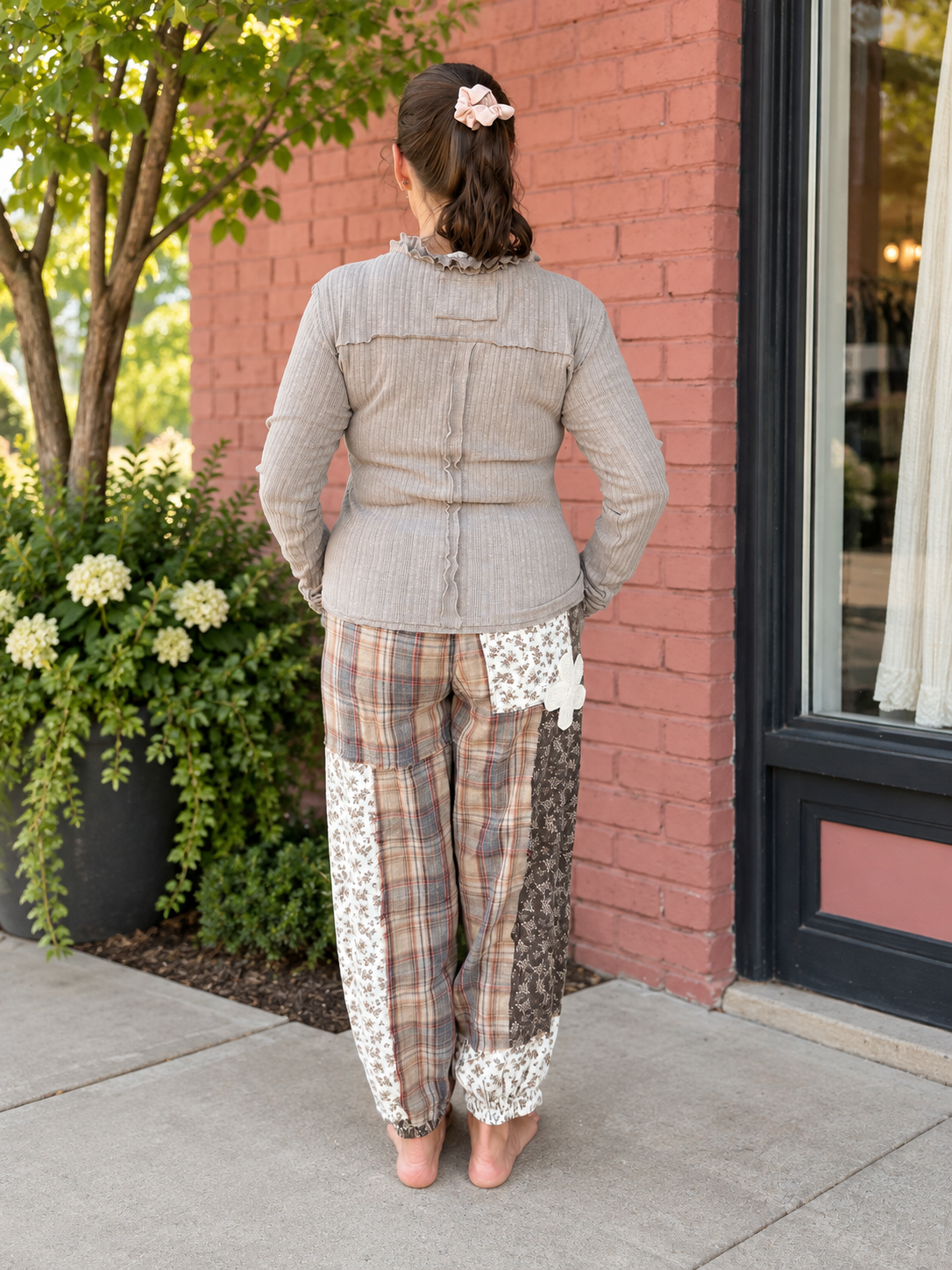 Back view Model wearing THISTLE & THREAD patchwork joggers with mixed floral and plaid panels

