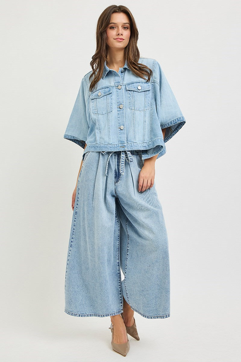 Woman wearing a denim outfit with a jacket and wide-leg pants on a white background