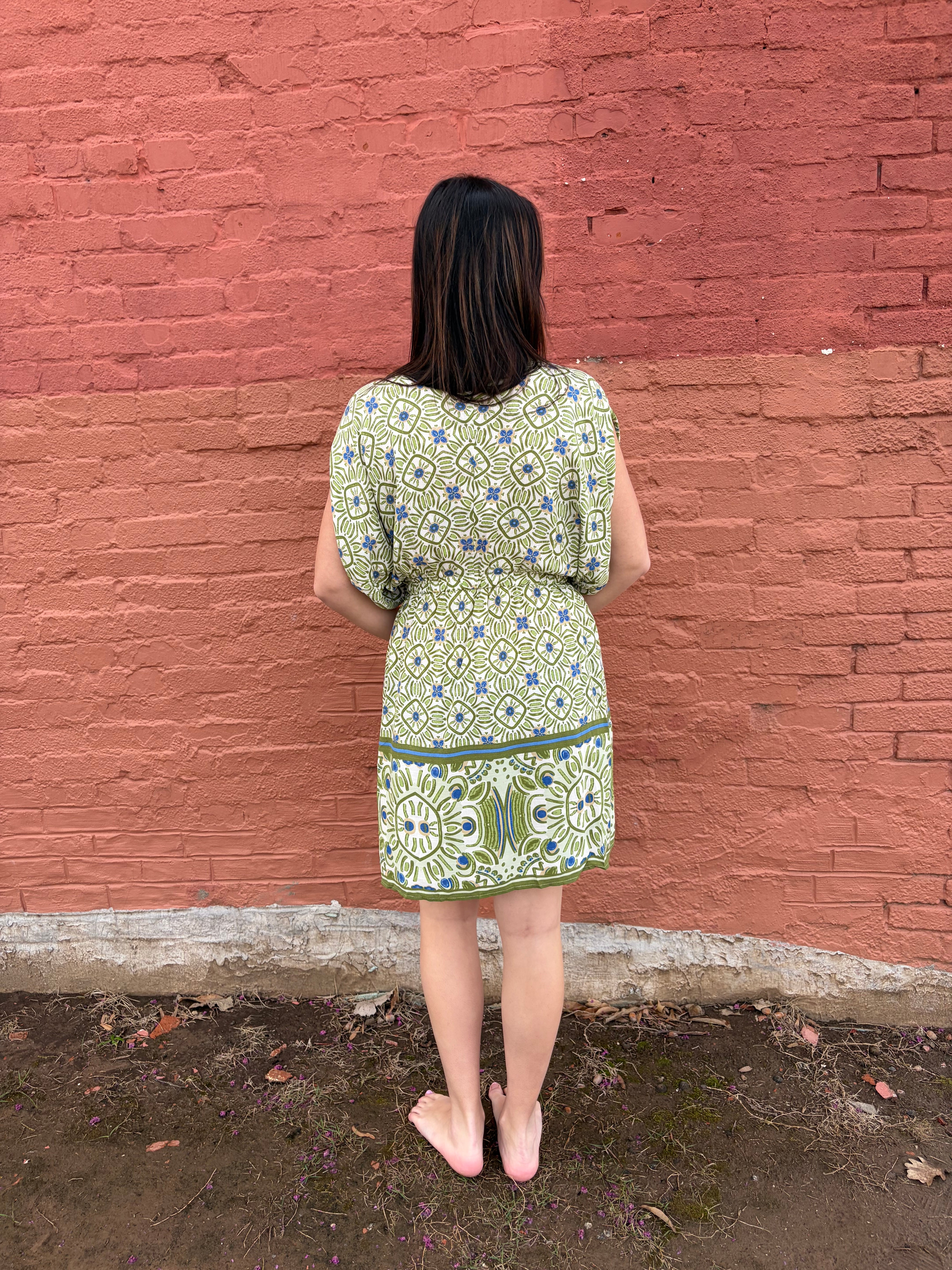 Back view of the model wearing the green Haydee Mini Dress