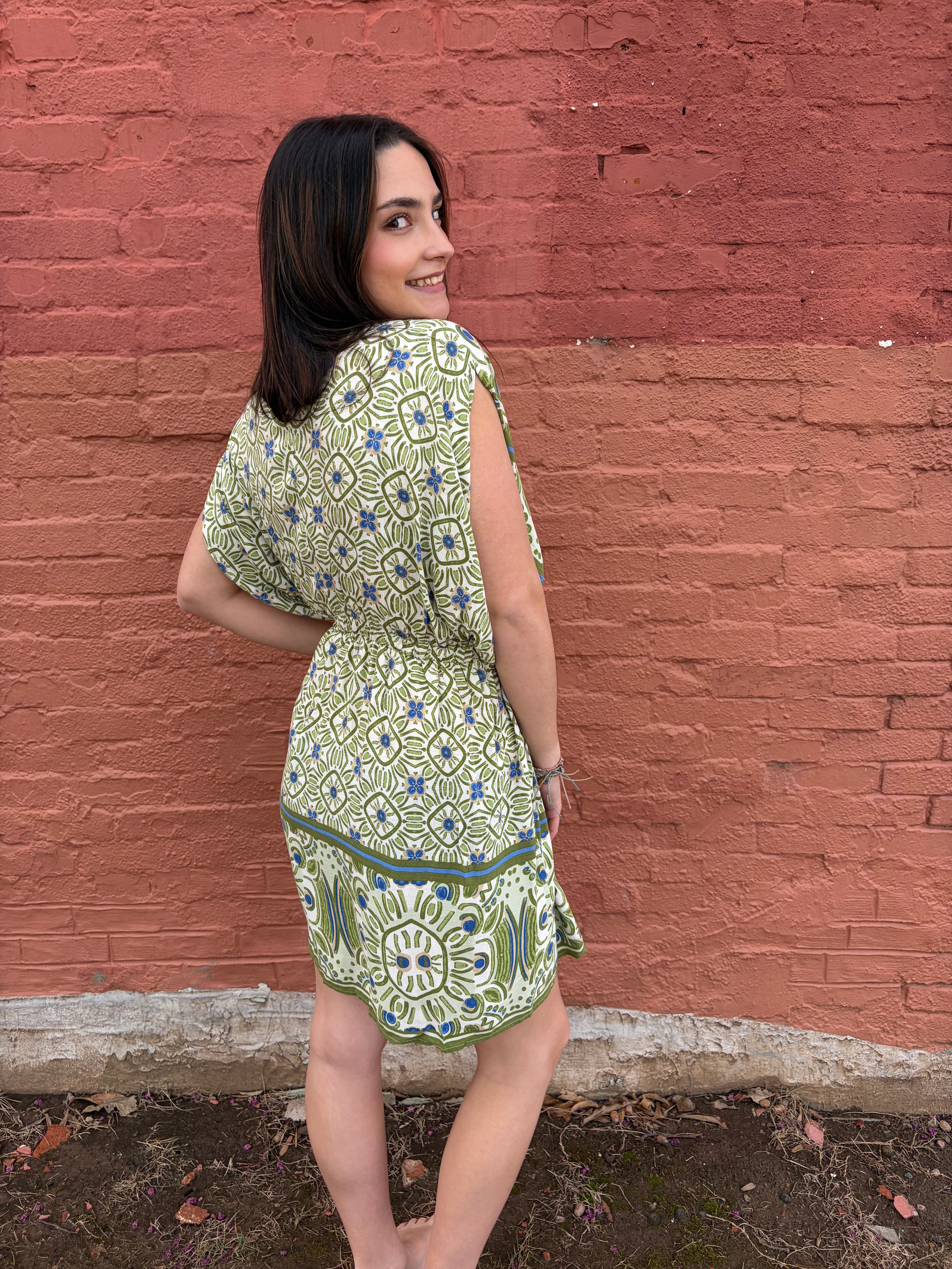 Back view of model wearing the green Haydee Mini Dress