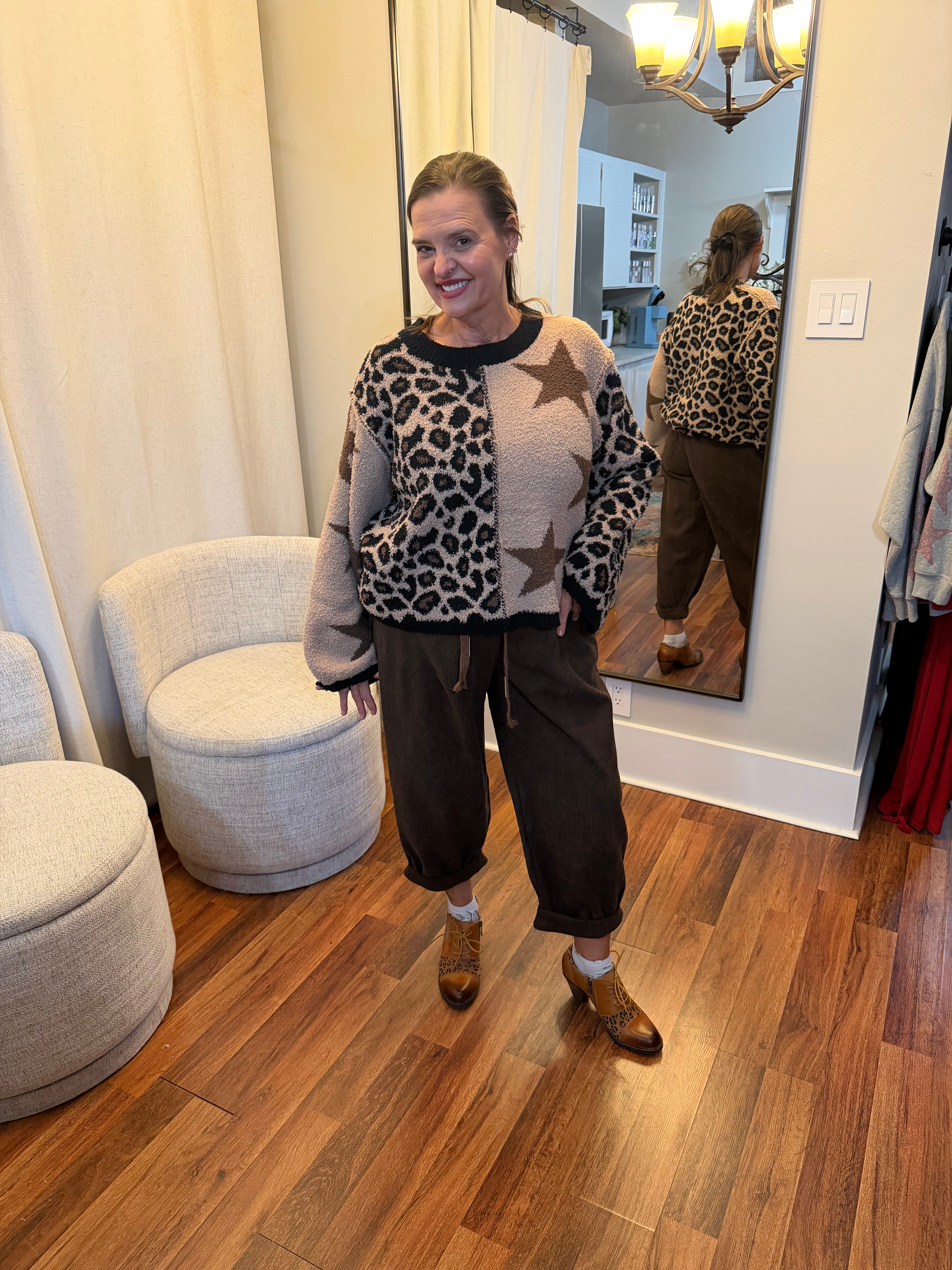 Model wearing high-waisted brown corduroy daddy pants with relaxed fit, drawstring waist, and rolled cuffs styled with a star and leopard patch sweater.