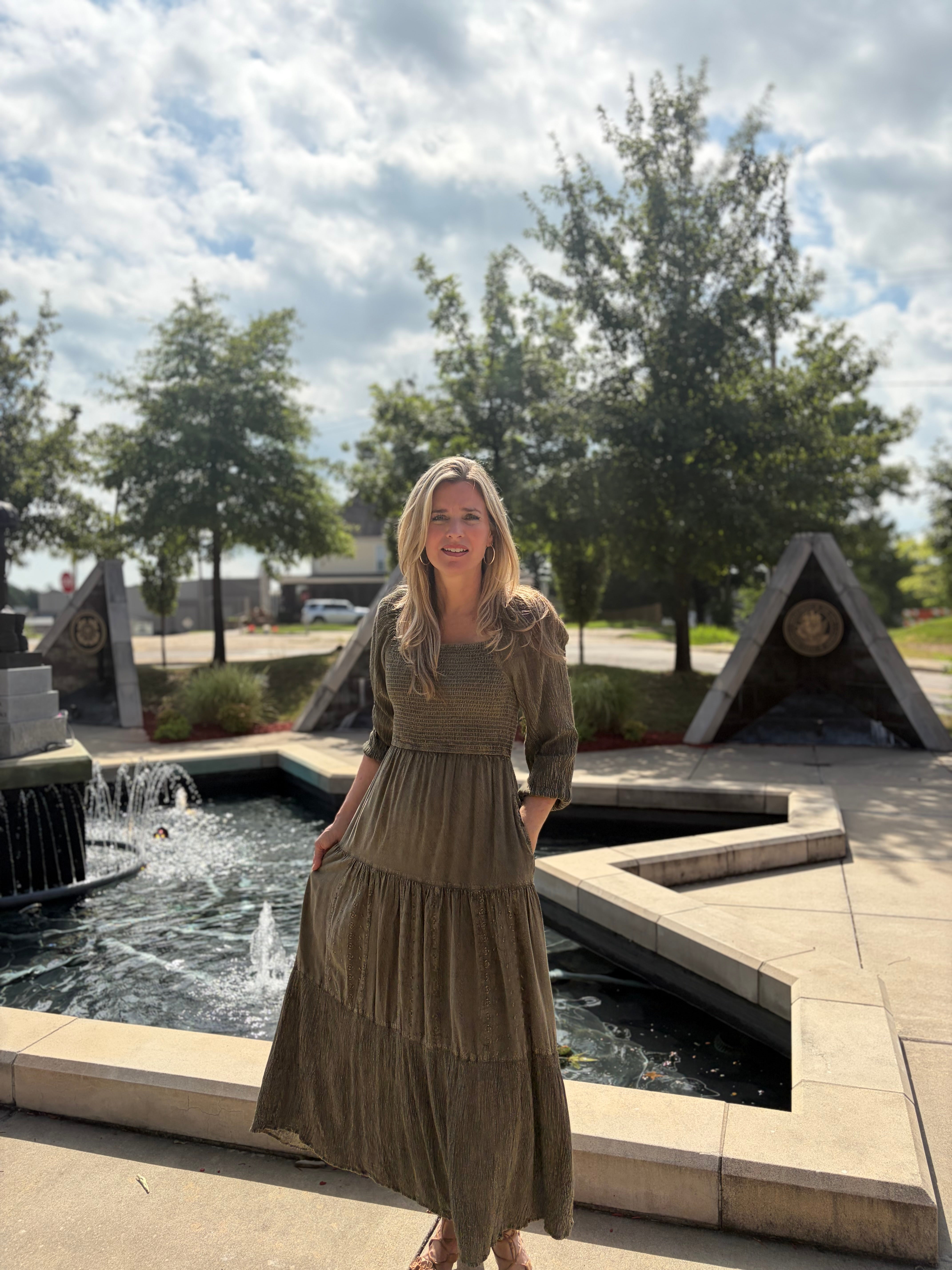 Gravel tiered maxi dress with smocked bodice and square neckline styled by a fountain — front view 