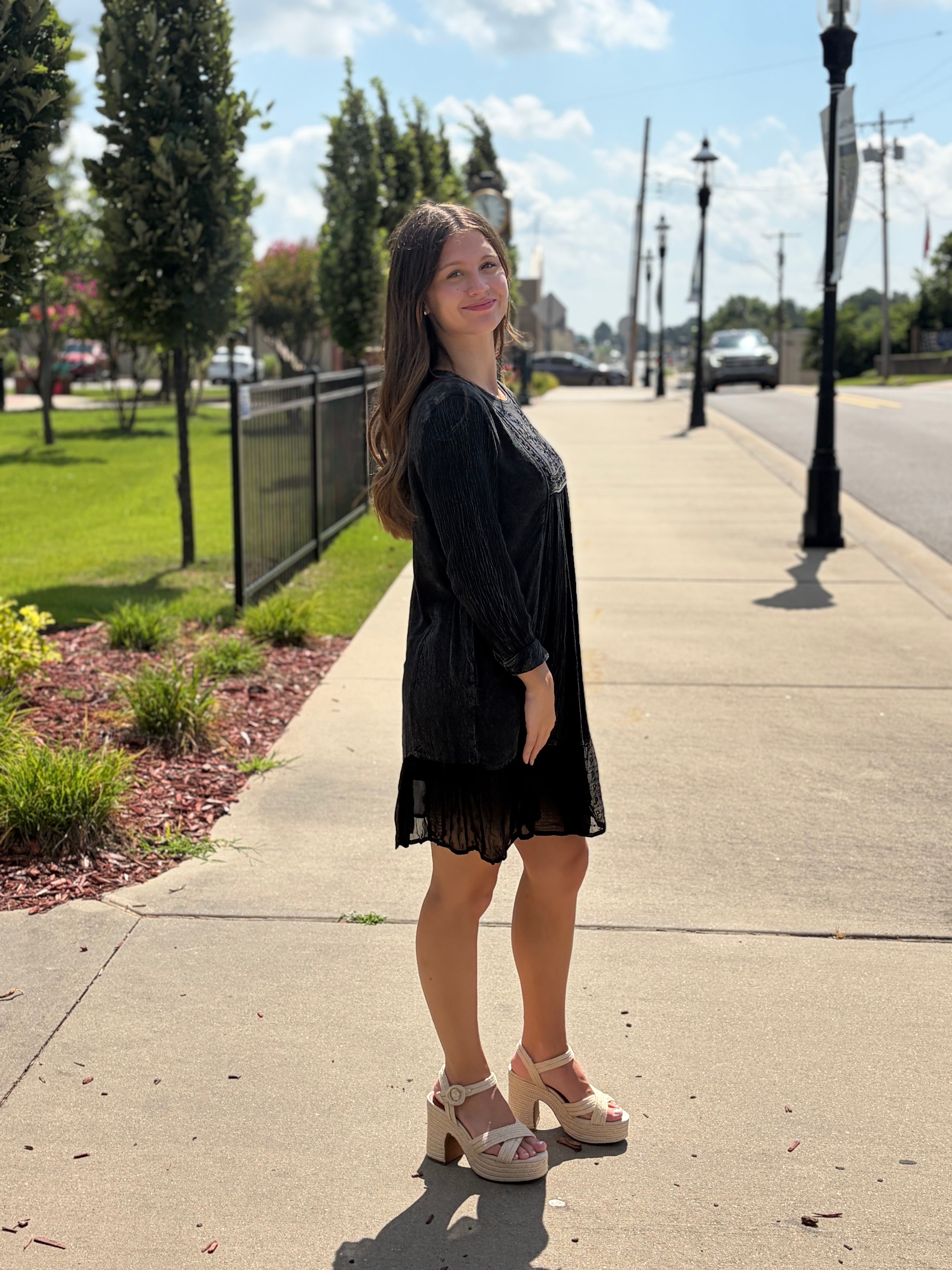 Black aari-embroidered babydoll dress with relaxed silhouette and lace ruffle hem styled with platform sandals