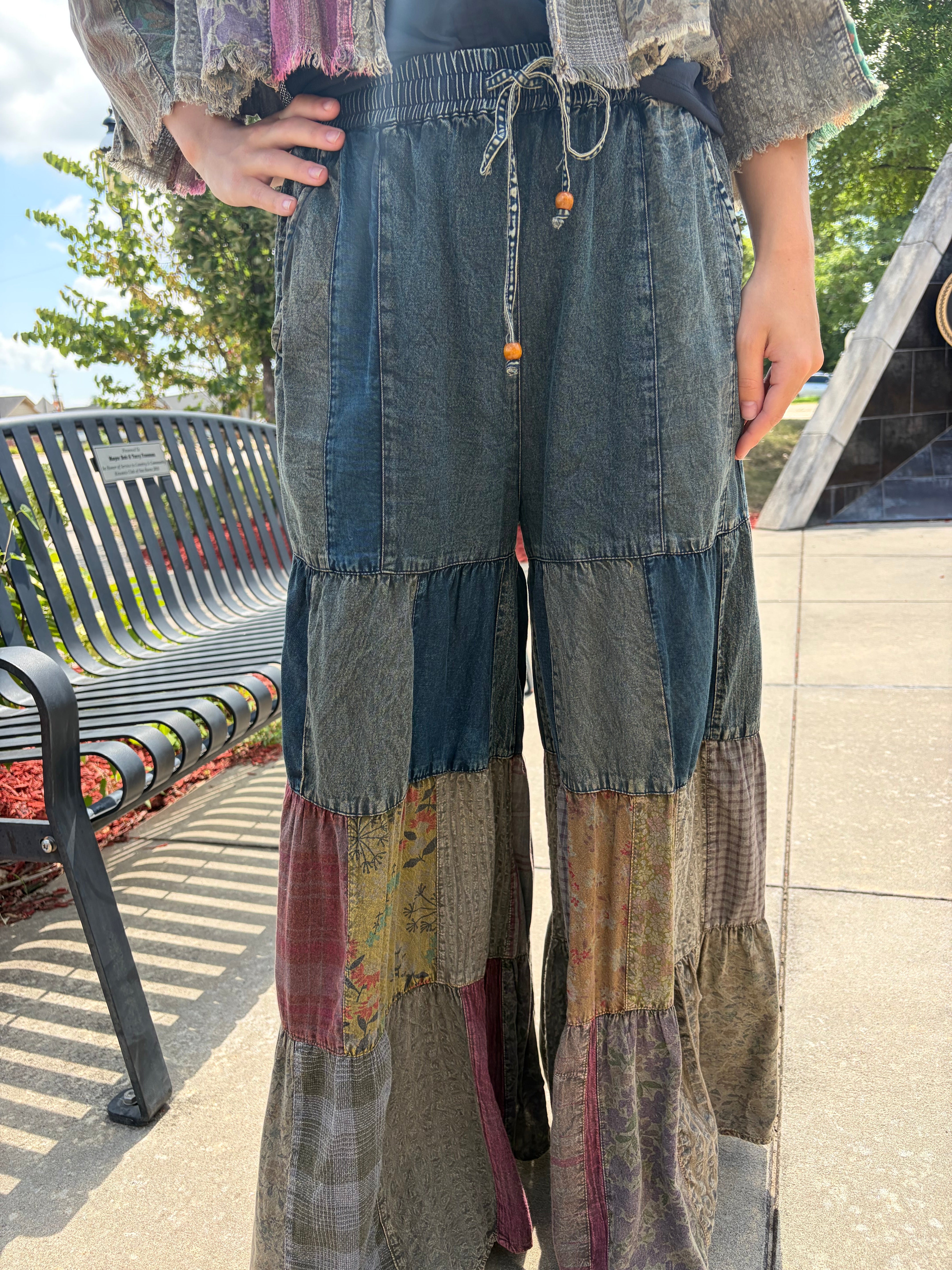 Close-up of latte patchwork flow pant showing stonewashed denim upper, drawstring waist, and tiered mixed-fabric patchwork legs