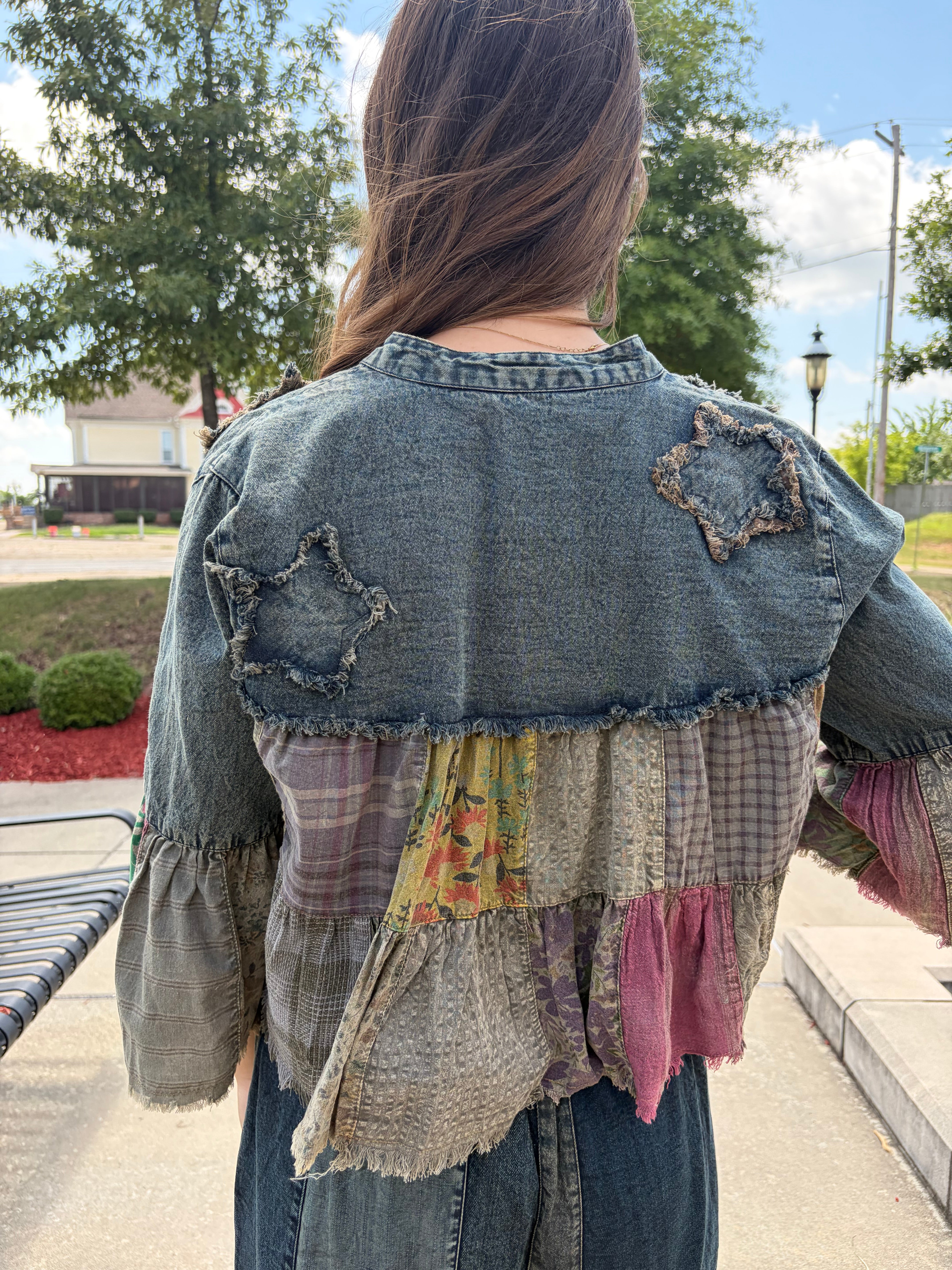 Back view close-up highlighting the denim yoke with distressed appliqué details and tiered patchwork panels in earthy tones