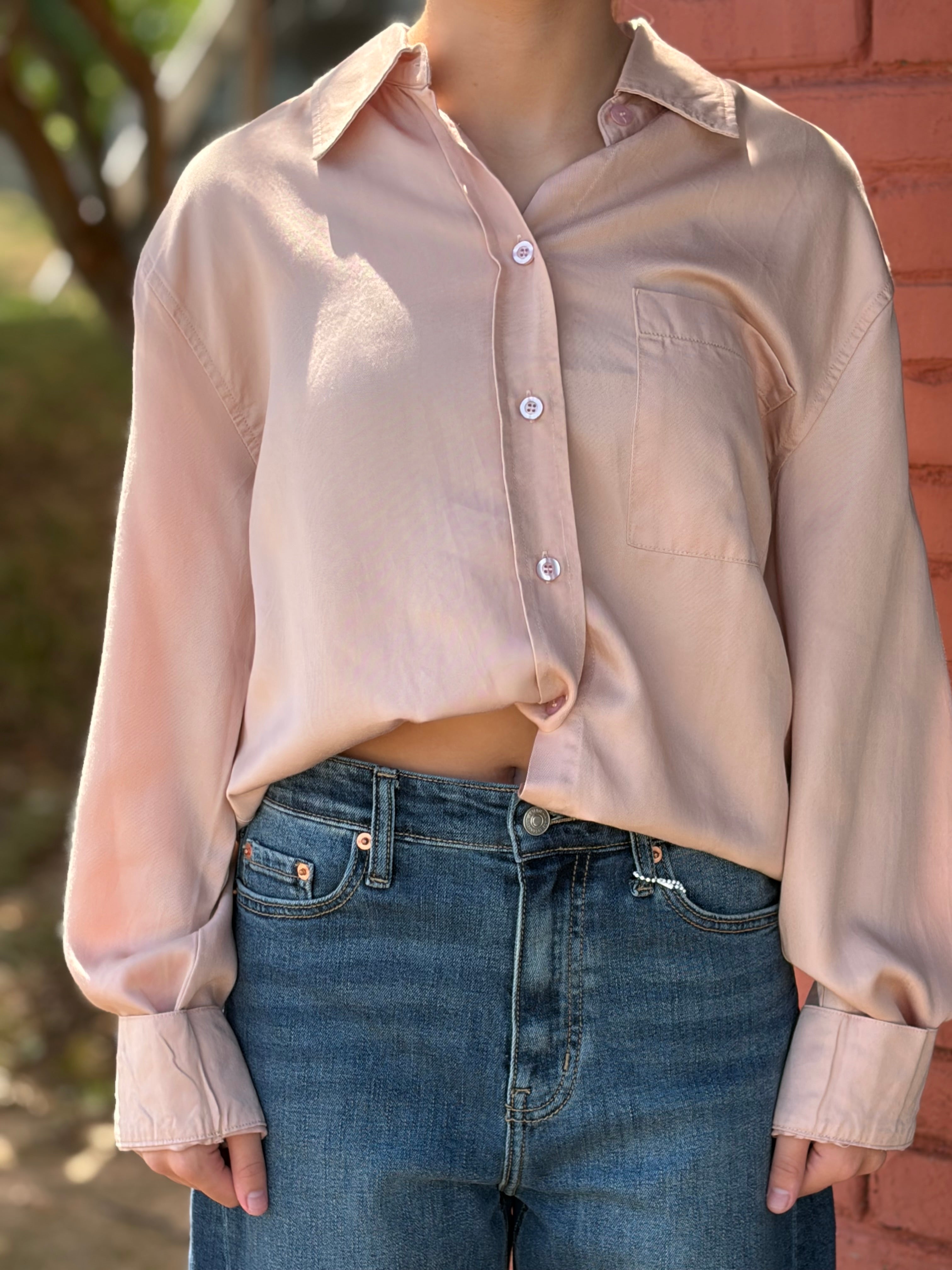 Close-up detail of chest pocket, buttons, and cuffed sleeves