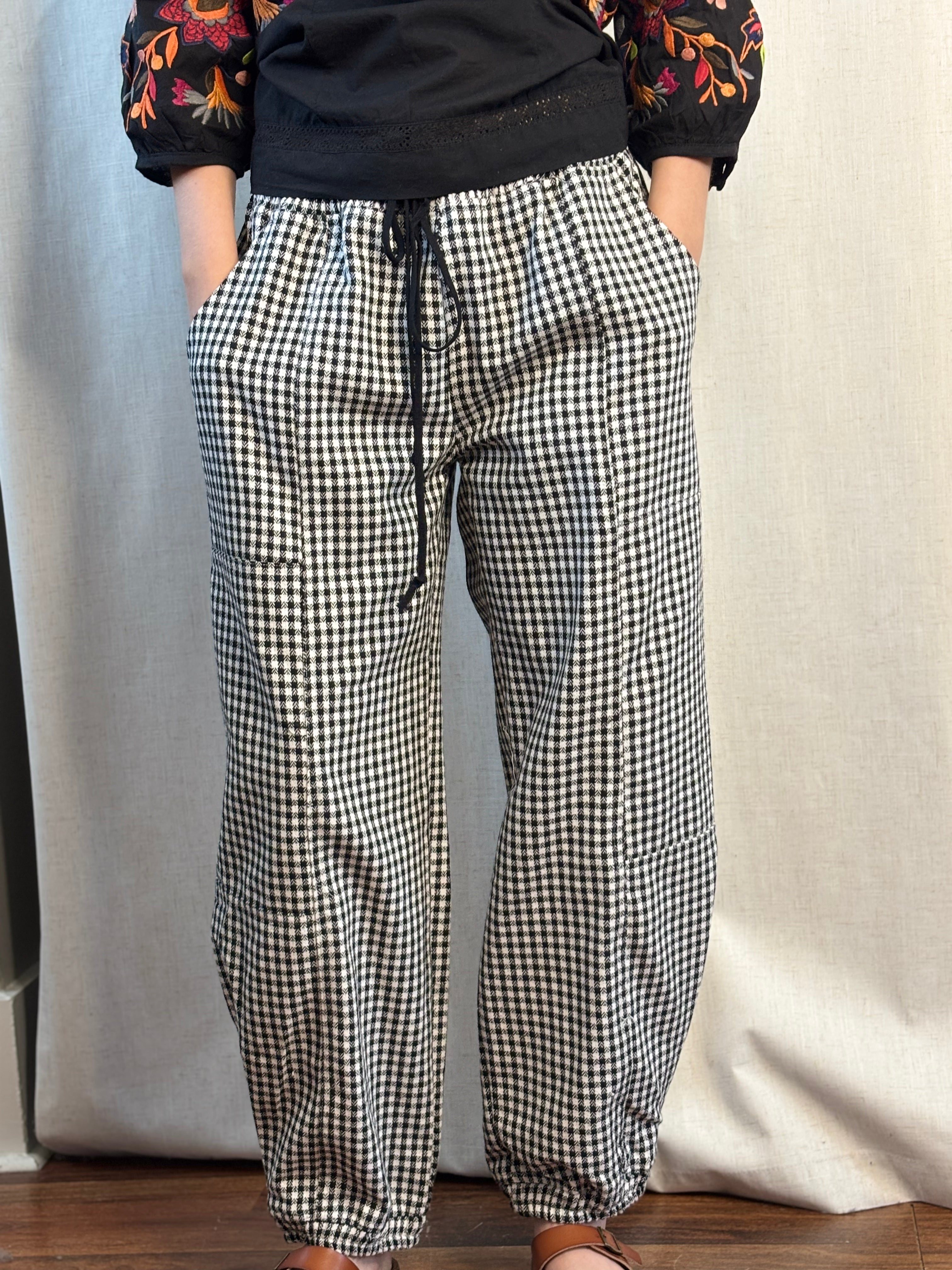 Close-up front view of NOABOA Mini Plaid Cuffed Barrel Pants in black and white houndstooth with elastic drawstring waist and side patch pocket