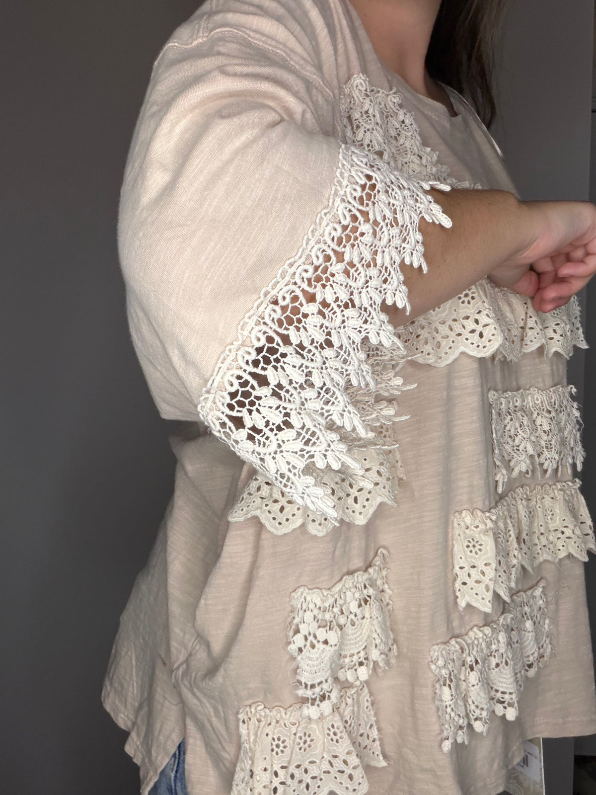 Close-up: sleeve lace trim and ruffle panel detail