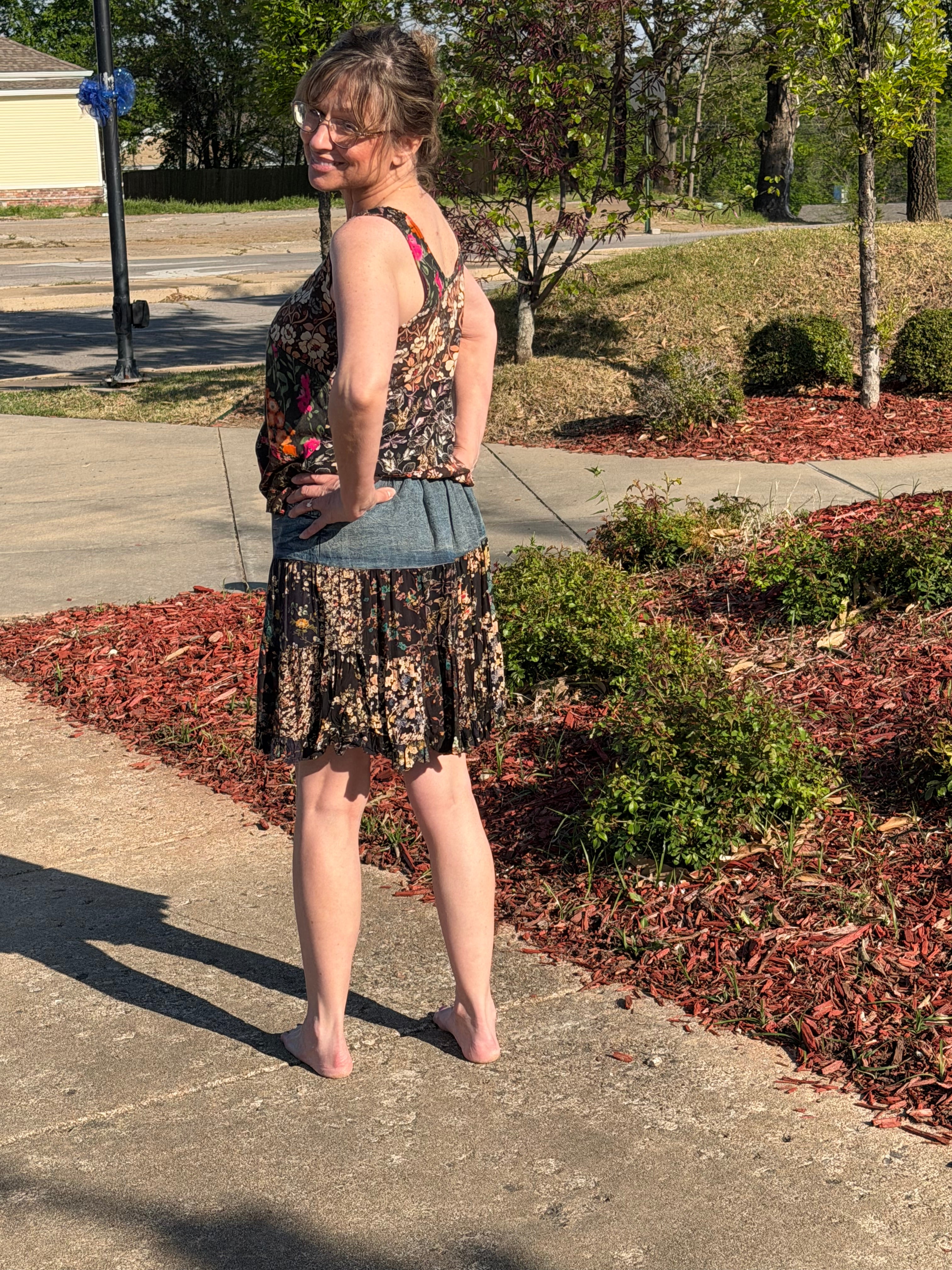 Back view of Boho Patchwork Denim Set – Sleeveless floral patchwork denim tank that has rayon print mini skirt with pockets | Spirit & Wind Boutique
