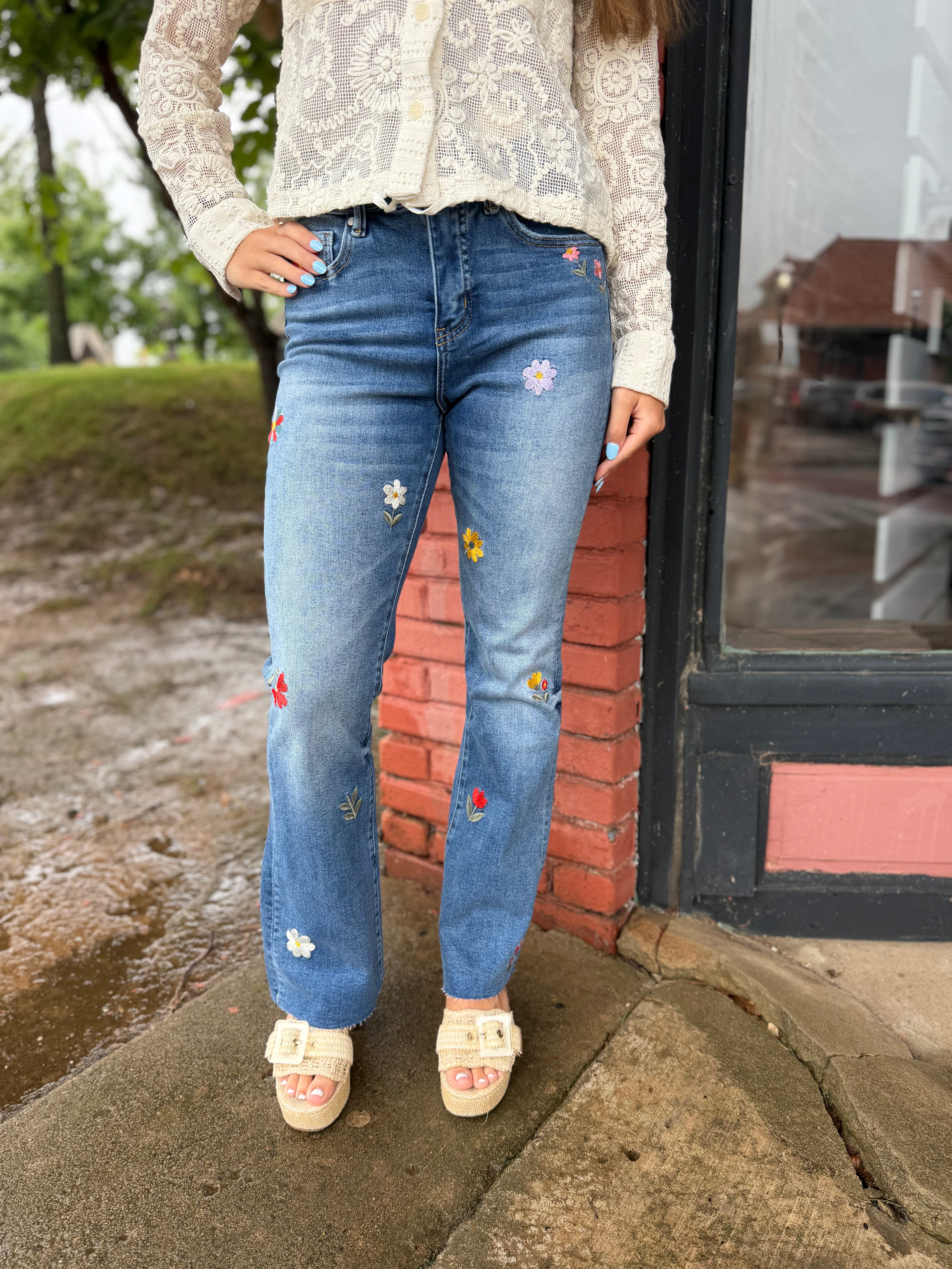 Model wearing Flower Embroidered Mid Rise Bootcut Jeans in Medium Blue"