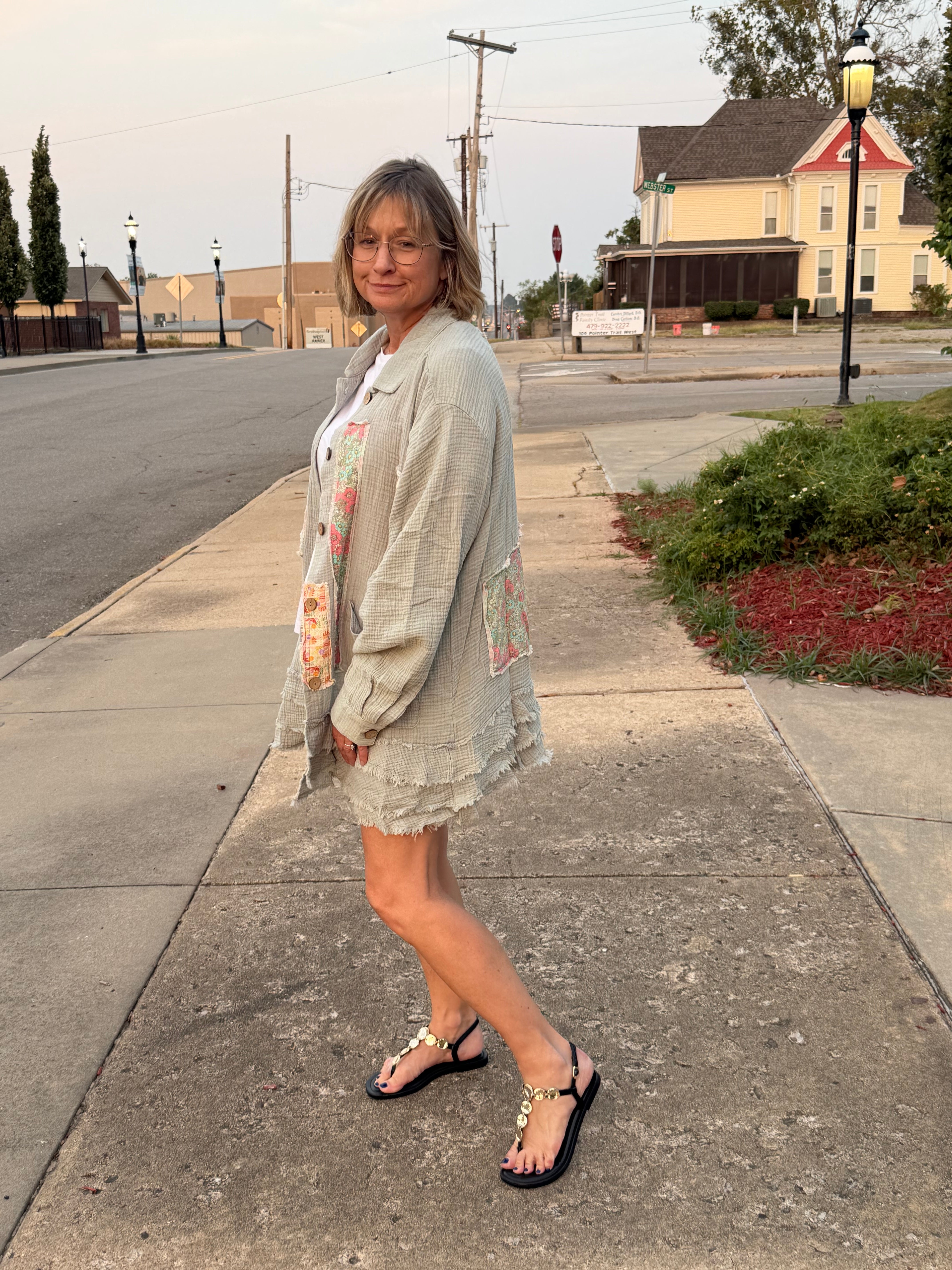 Side view of woman wearing Blue Velvet sage gauze patchwork shirt open over white tee showing patchwork front placket and frayed ruffle hem detail
