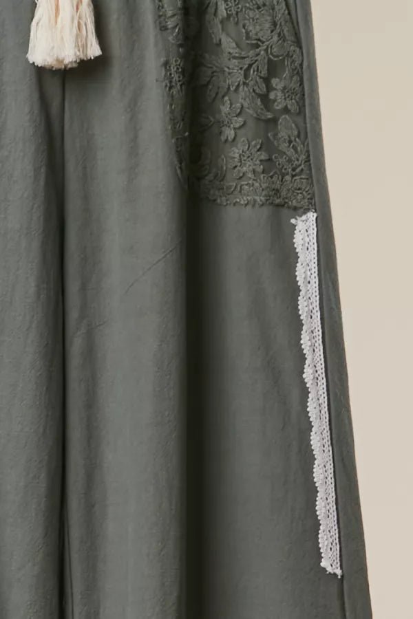 Dark gray dress with lace detailing on a beige background