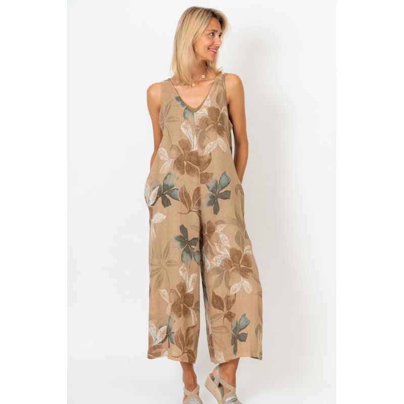 Woman wearing a beige floral jumpsuit on a white background