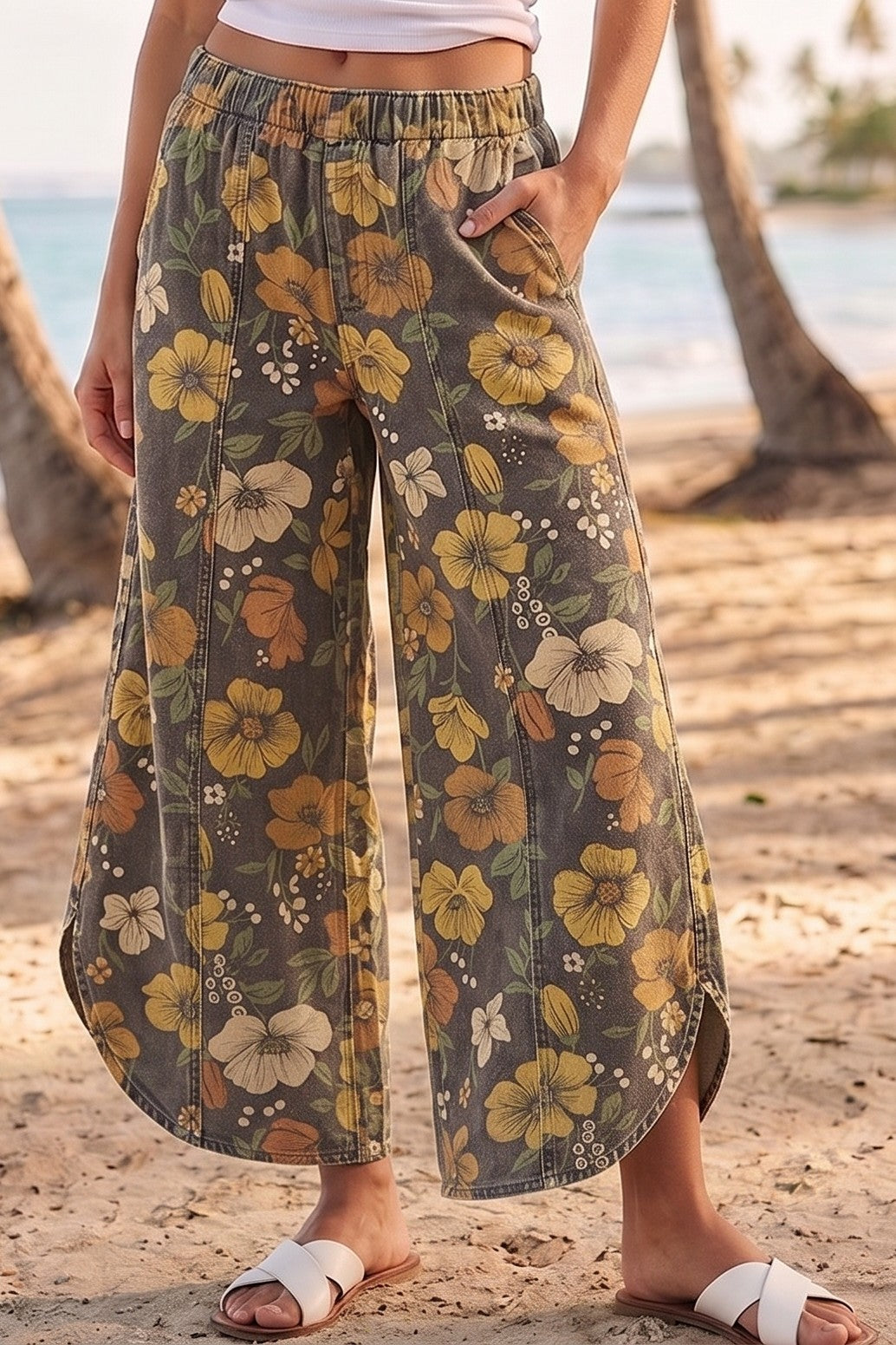 Person wearing floral wide-leg pants on a beach