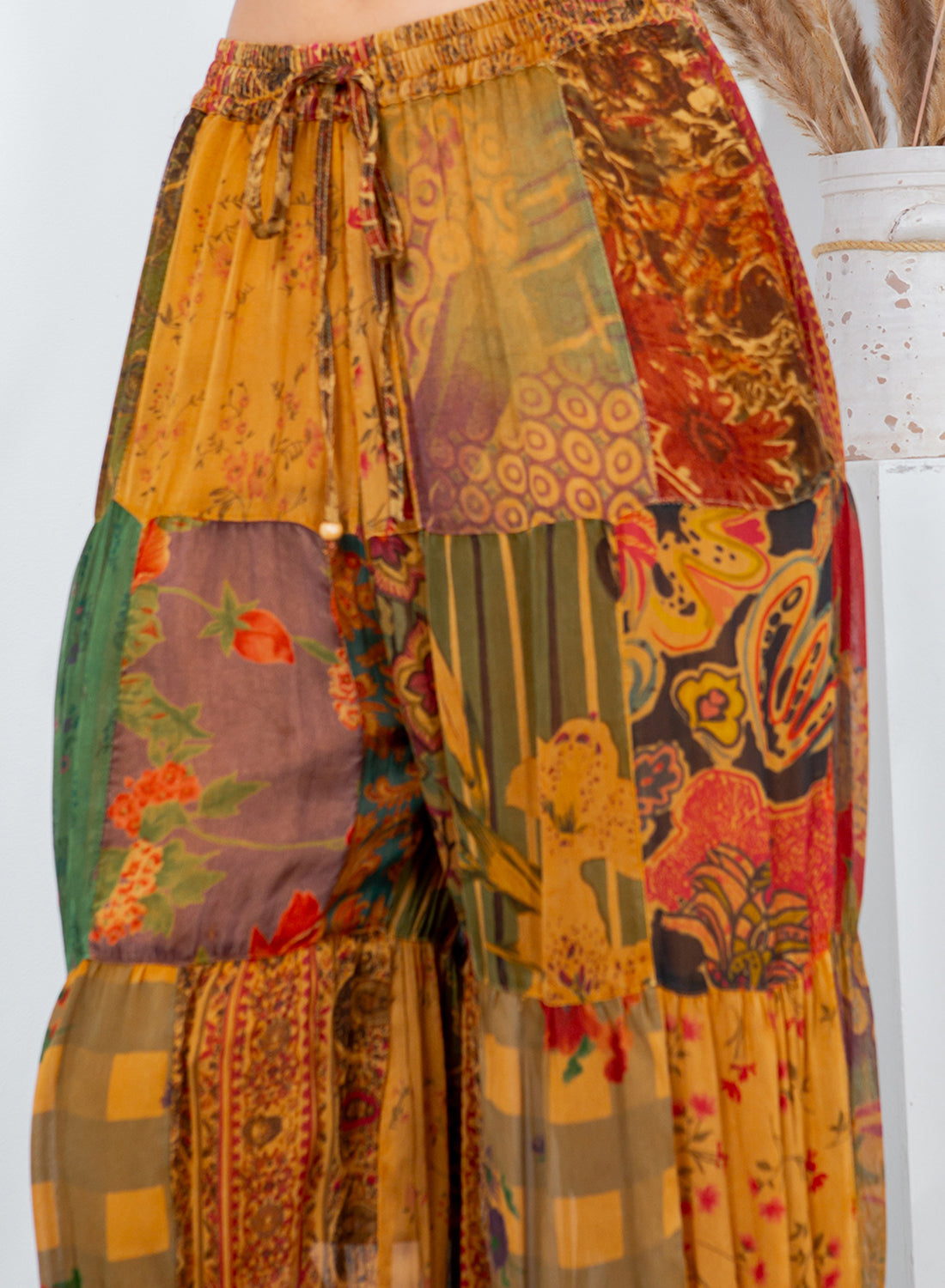 Colorful patchwork pants with floral patterns on a white background