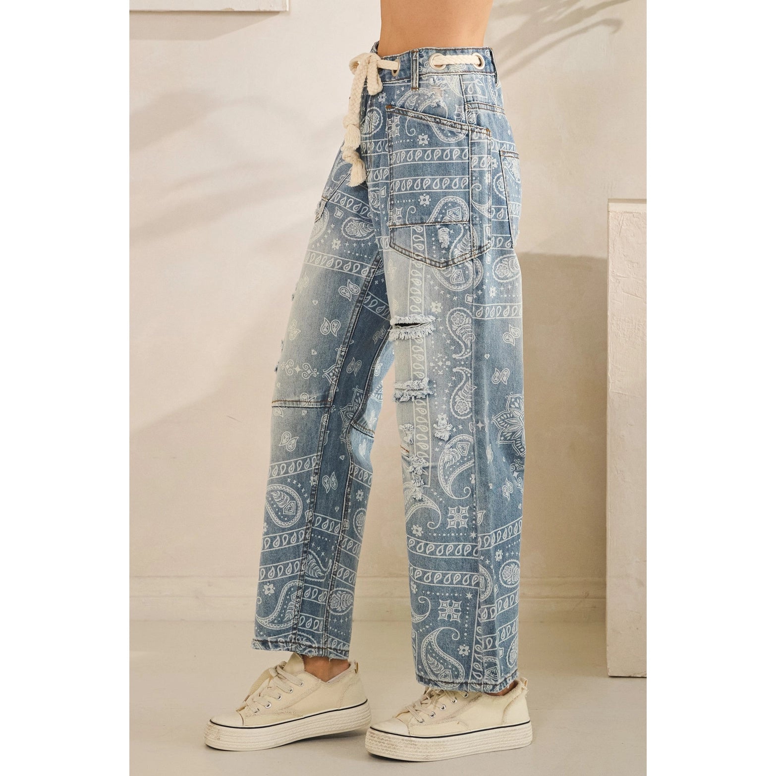 Blue paisley patterned jeans worn by a person indoors.