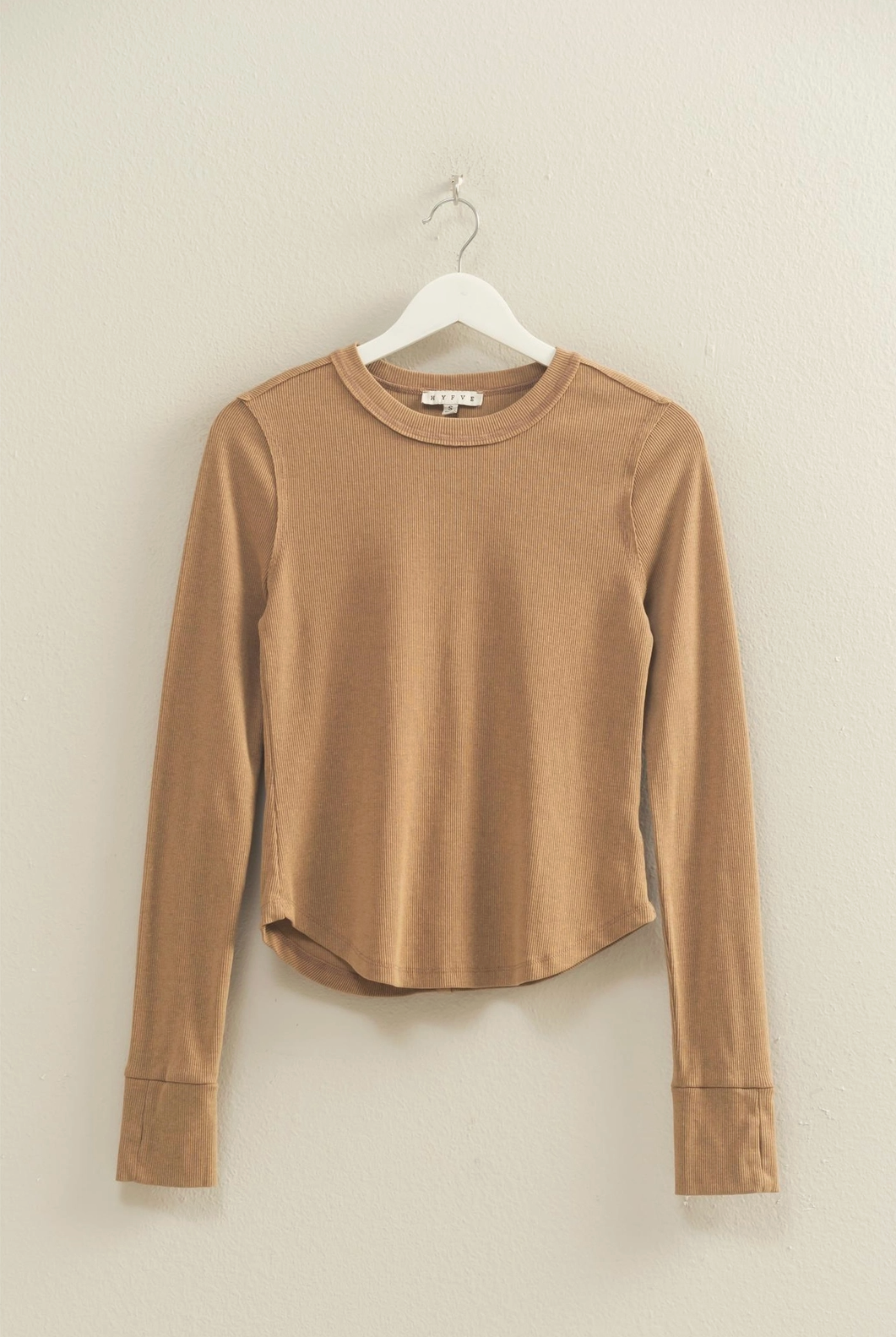 Brown long-sleeve shirt on a hanger against a beige wall