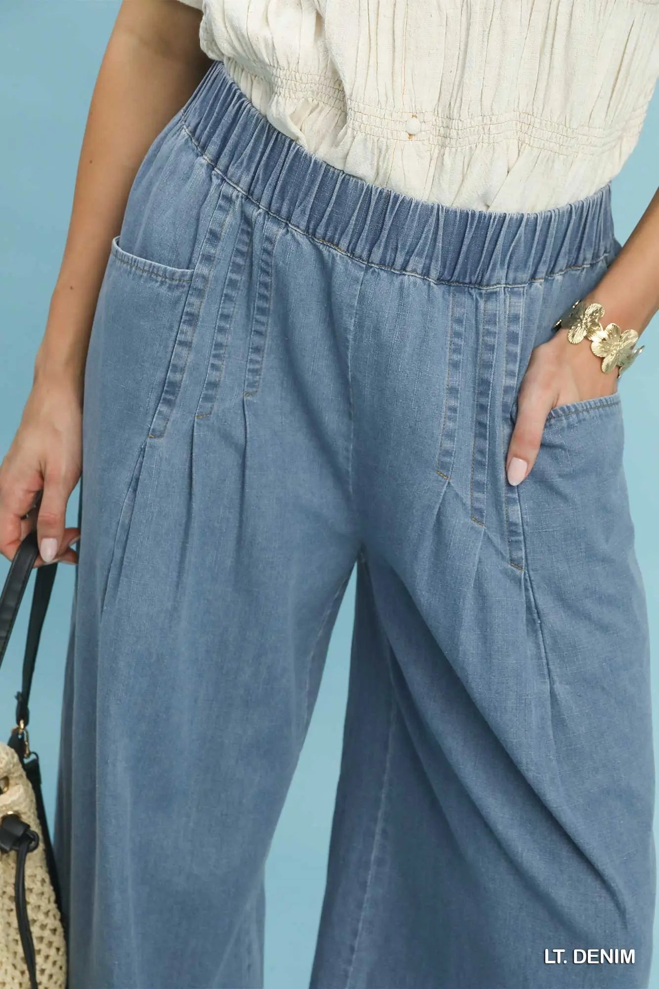 Light blue denim pants worn by a person against a light blue background