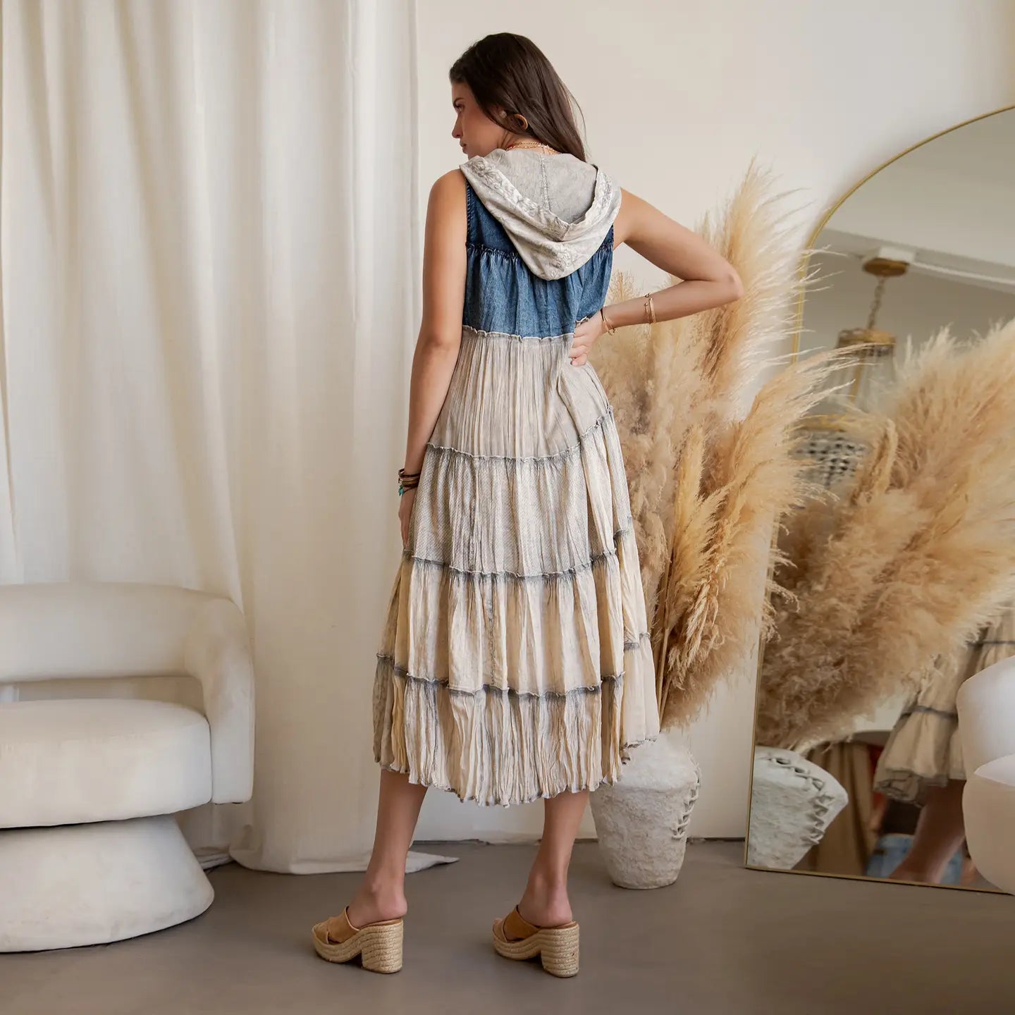 A woman wearing a tired denim and latte dress 