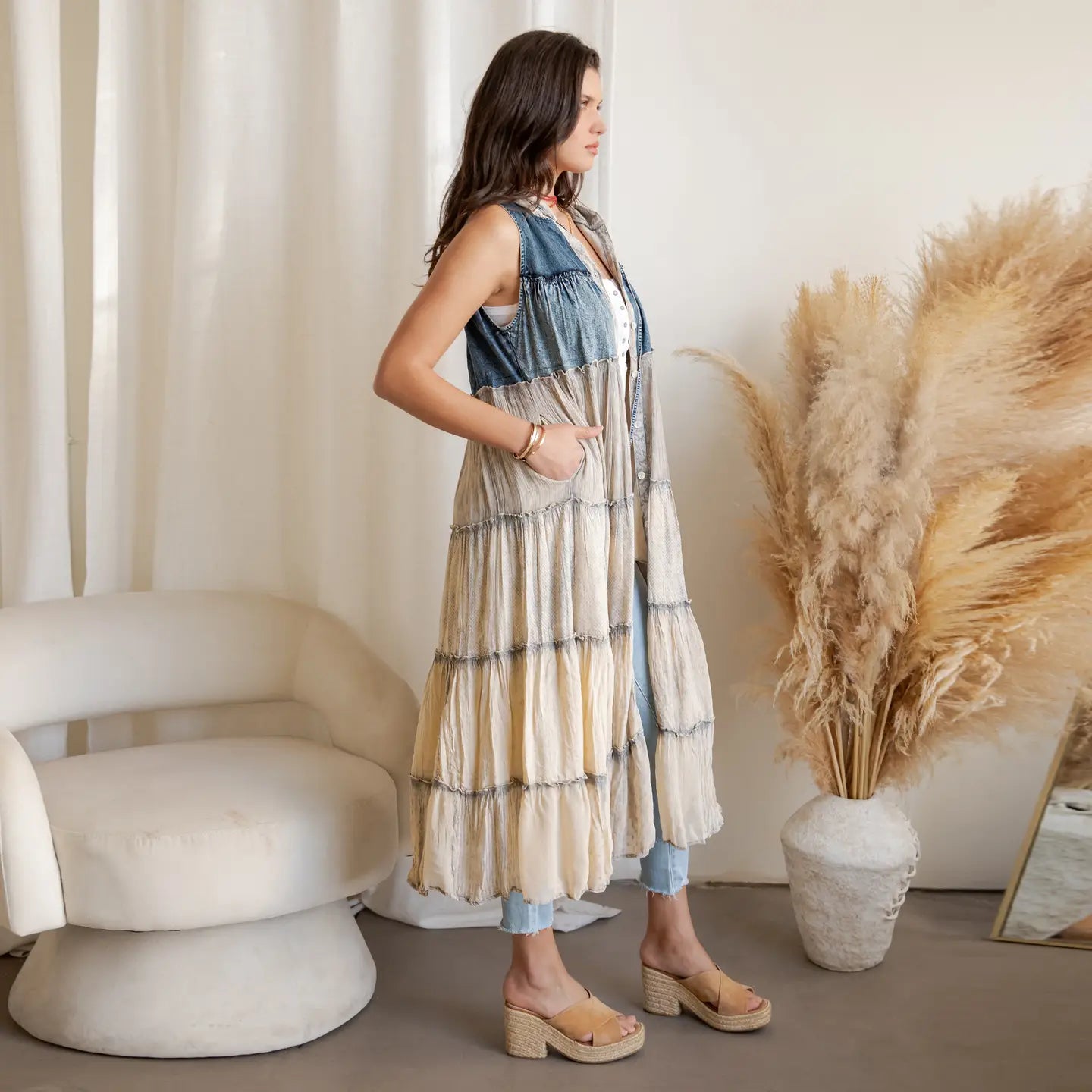 A woman wearing a tired denim and latte dress 