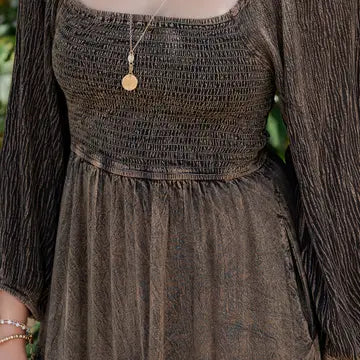 Close-up of amber tiered maxi dress smocked bodice with square neckline and long sleeves 