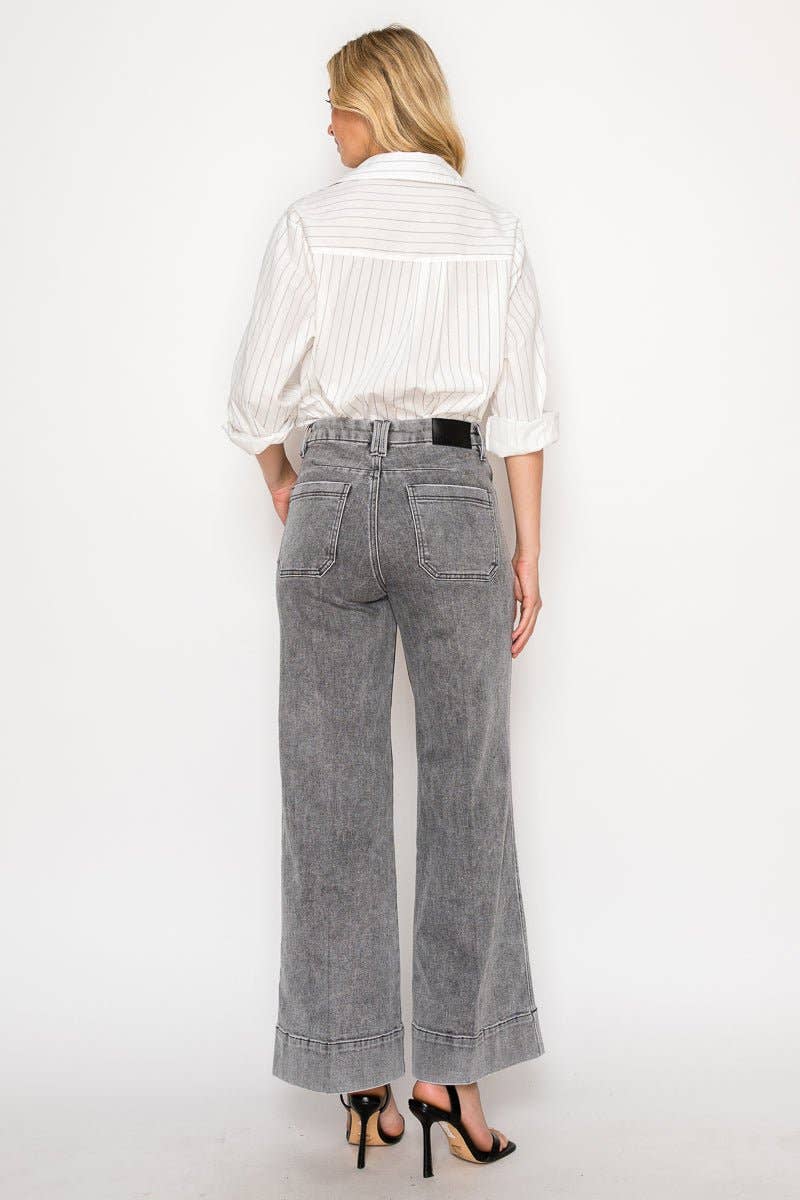 Person wearing a white striped shirt and gray jeans on a white background