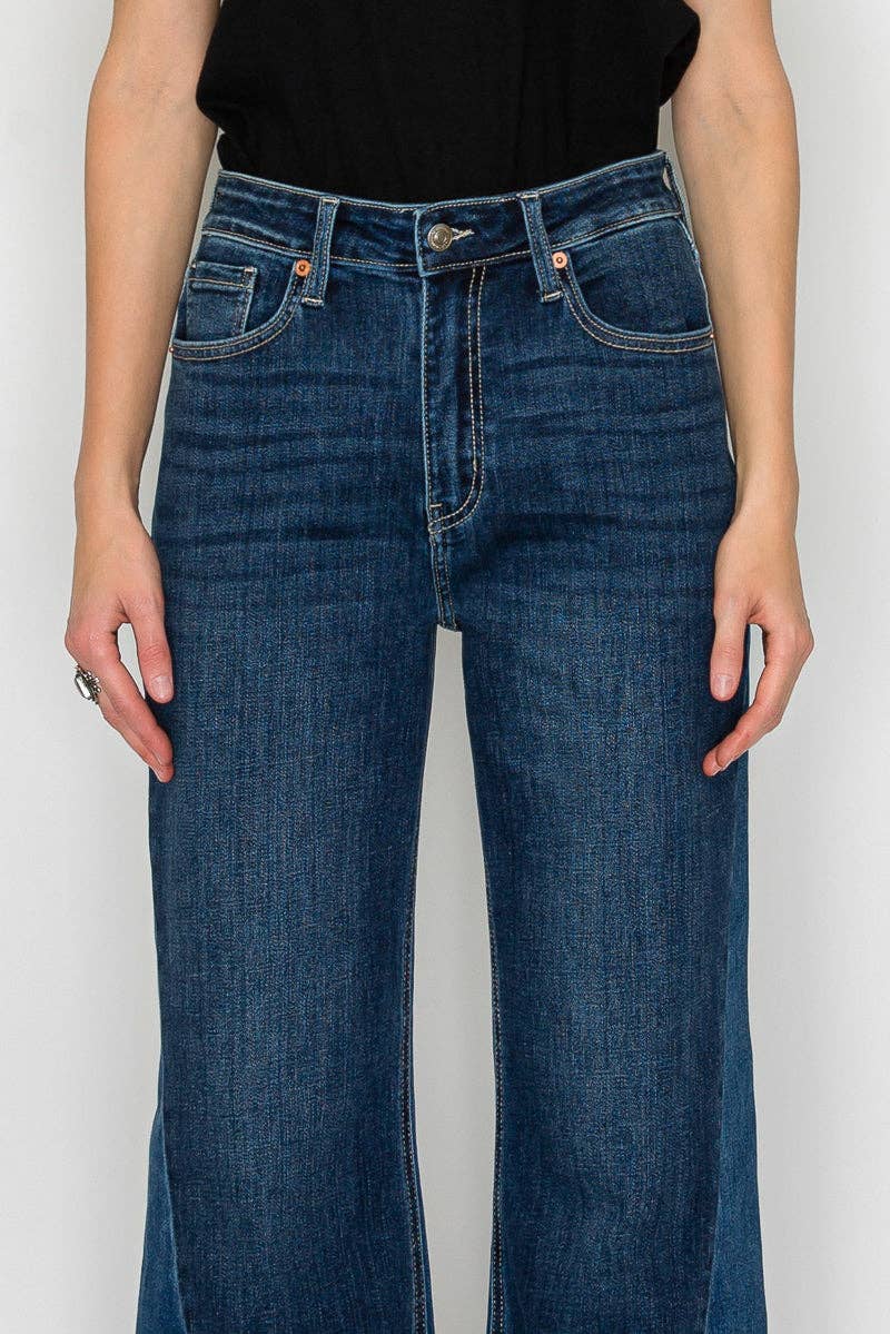 High-rise flare jeans detail - close-up of two-tone panel detailing and unique hem treatment on dark stone