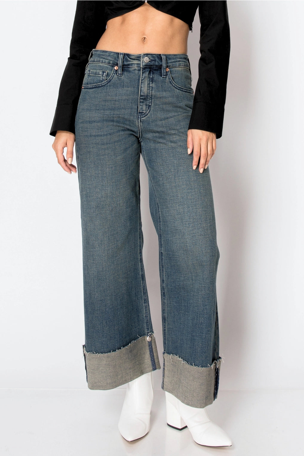 Front view — dark-wash high-rise wide-leg jeans with extra-wide cuffed hems and raw edge, 5-pocket style on model.