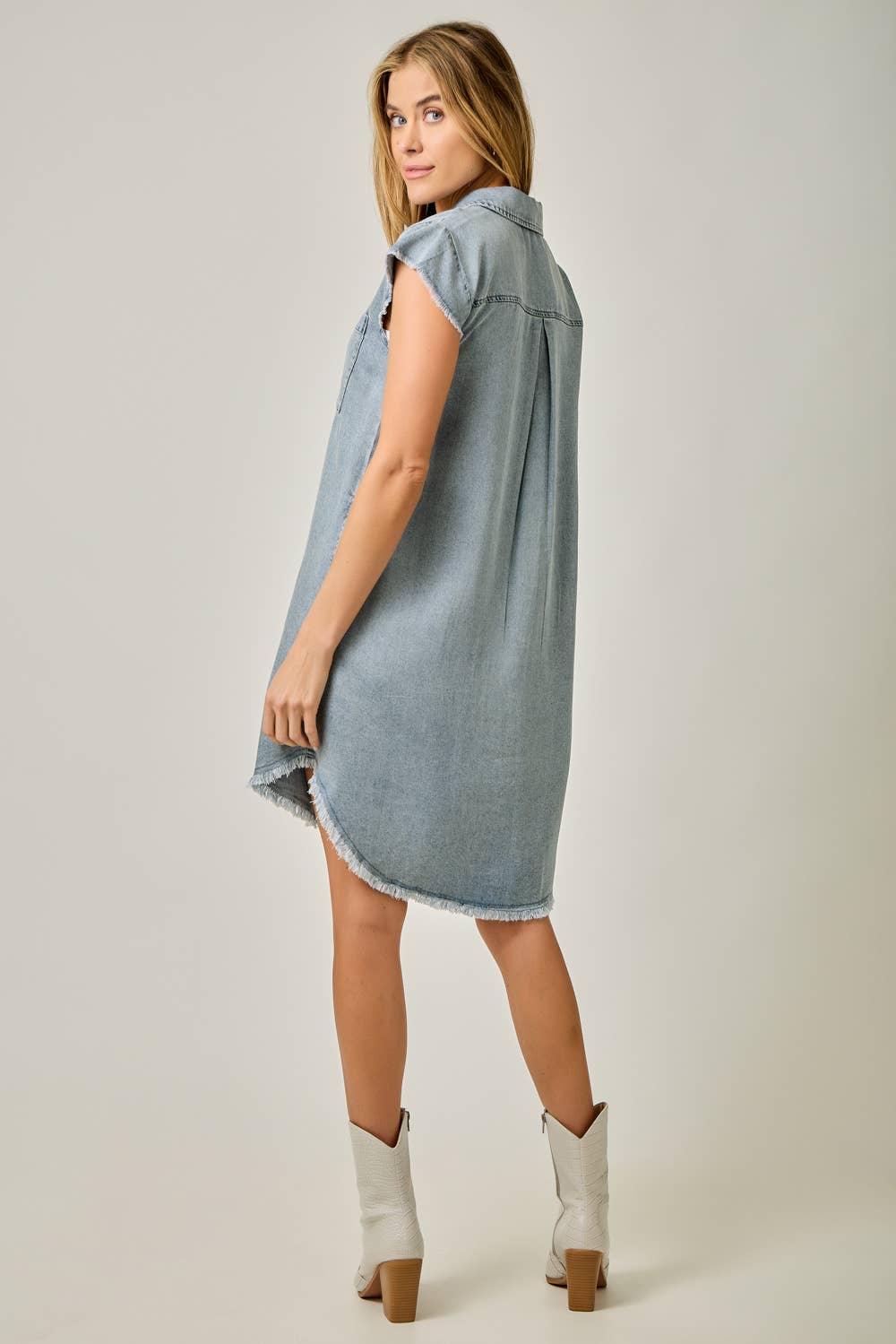 Back view Fringe Hem Tencel Shirt Dress in Light Denim Blue — button-down front, flutter cap sleeves, fringed hi-lo hem, and side pockets

