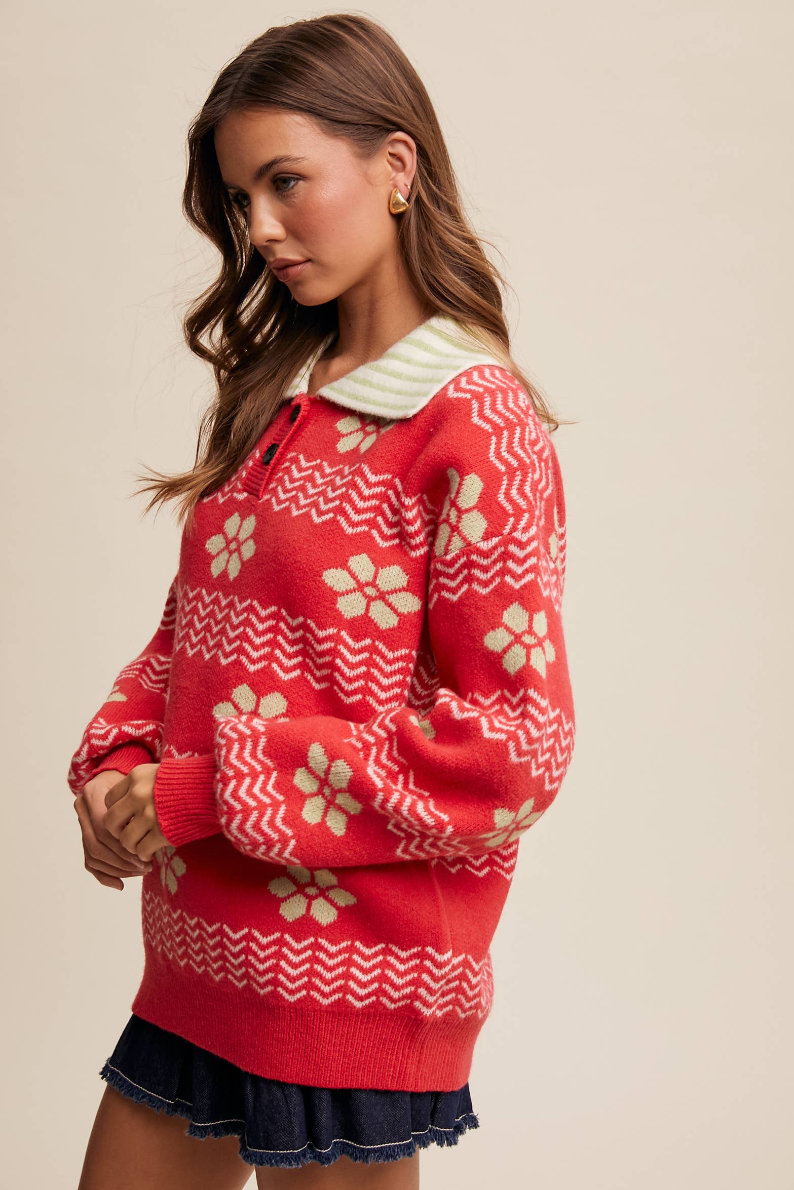 Woman wearing a red sweater with white patterns on a beige background