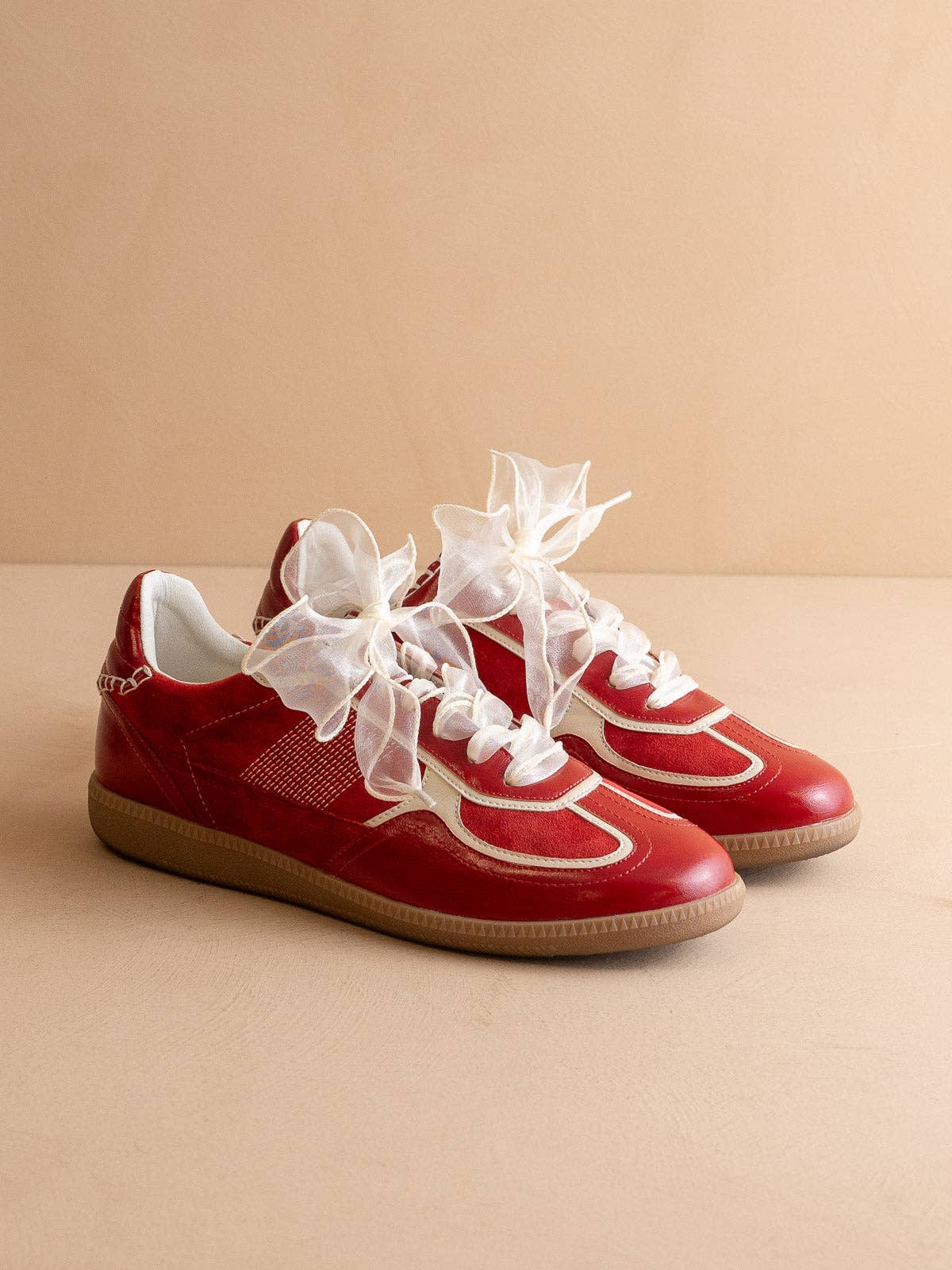 Cherry red Oasis Society sneakers with cream detailing and two lace options — organza ribbon and classic cotton.