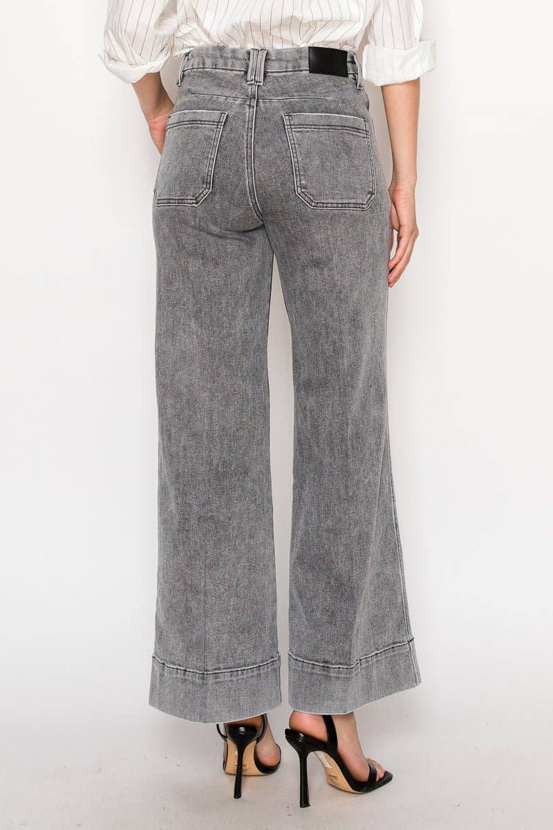 Person wearing gray wide-leg jeans on a white background