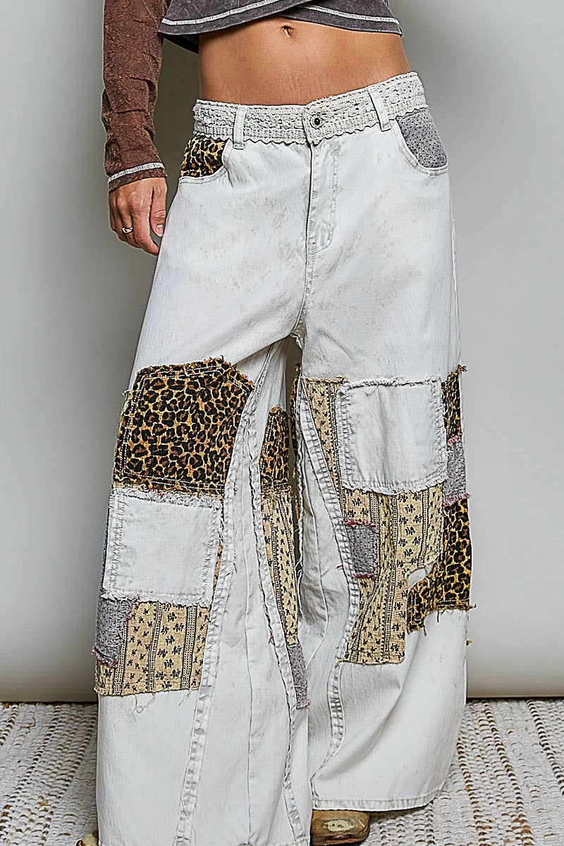 White patchwork pants with leopard print accents worn by a person.
