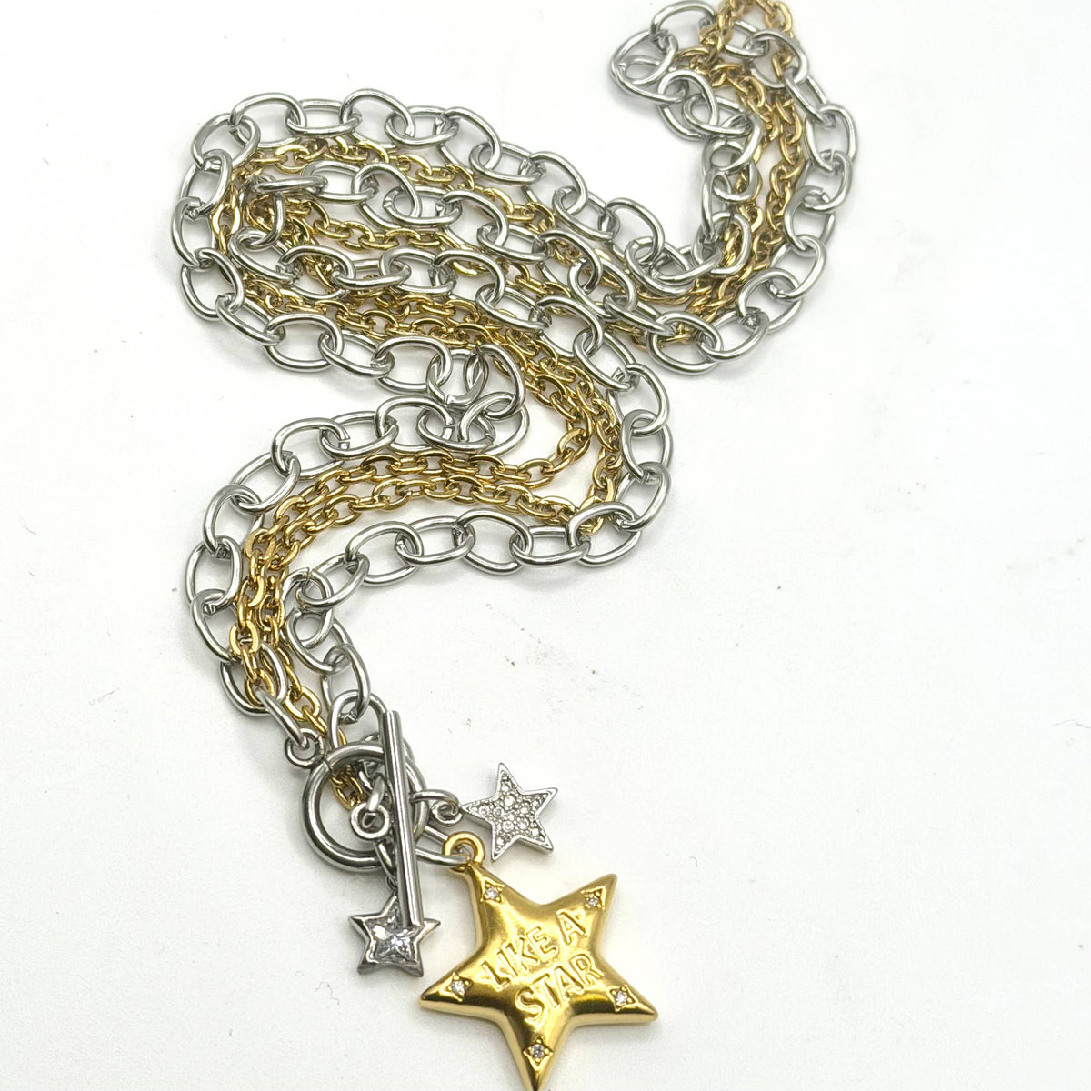 Necklace: Mixed-metal necklace with silver- and gold-tone chains, a toggle clasp, two small silver stars, and a gold star engraved “Like a Star.”

